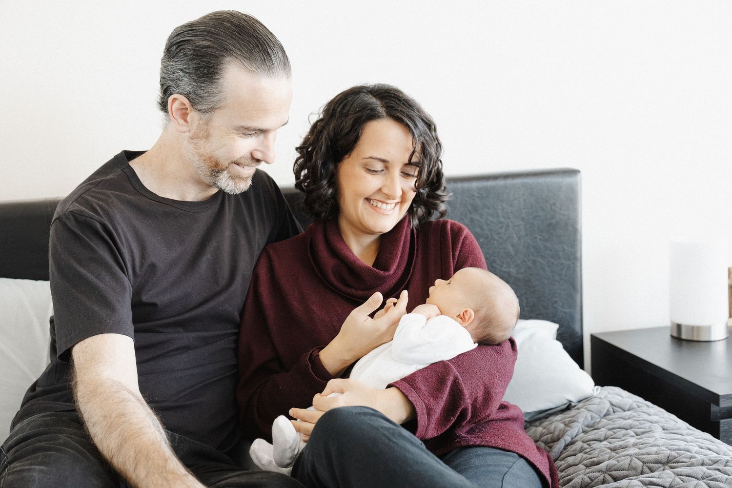 Two parents dote on their baby girl in an in-home newborn photoshoot in Canberra
