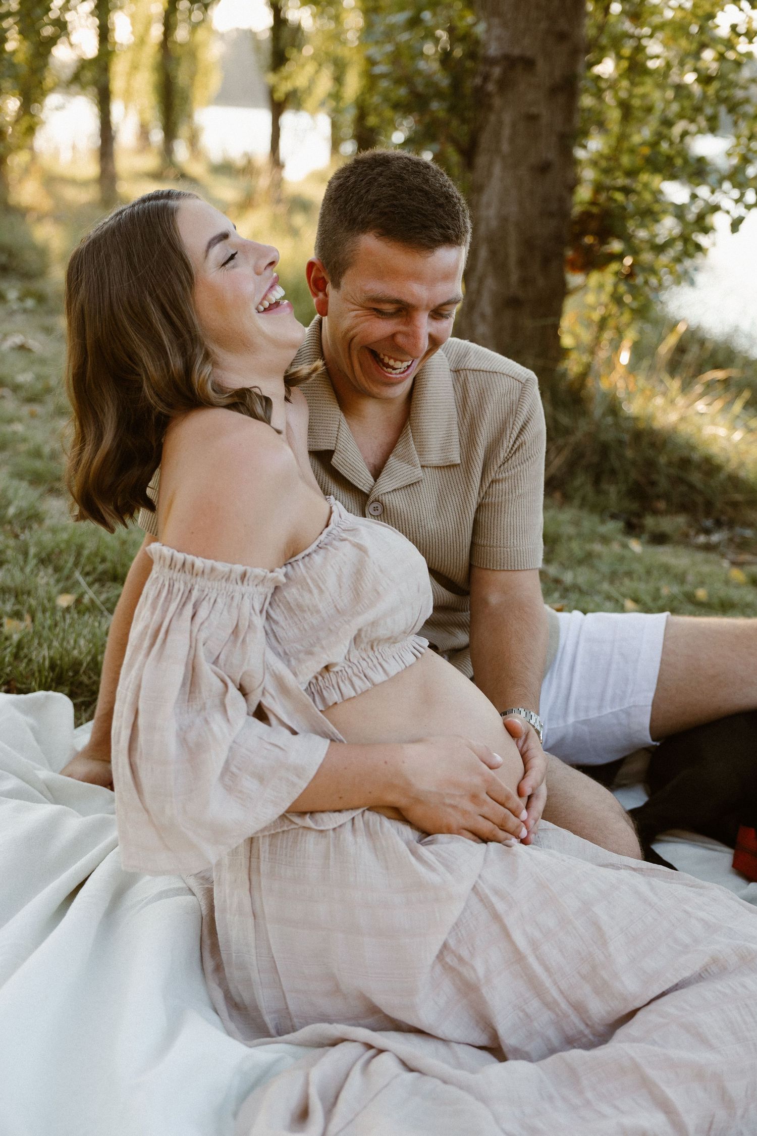 Laughing couple during an outdoor maternity photoshoot in Canberra