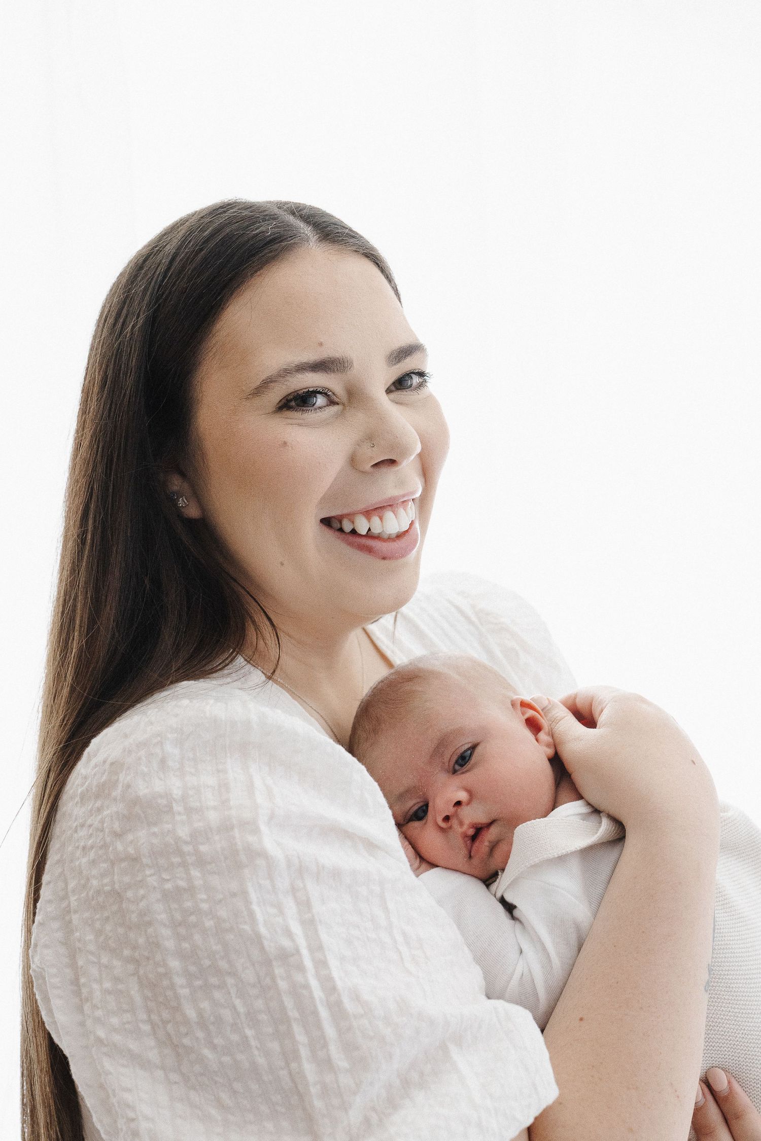 smiling mum cuddles baby in Canberra photography studio