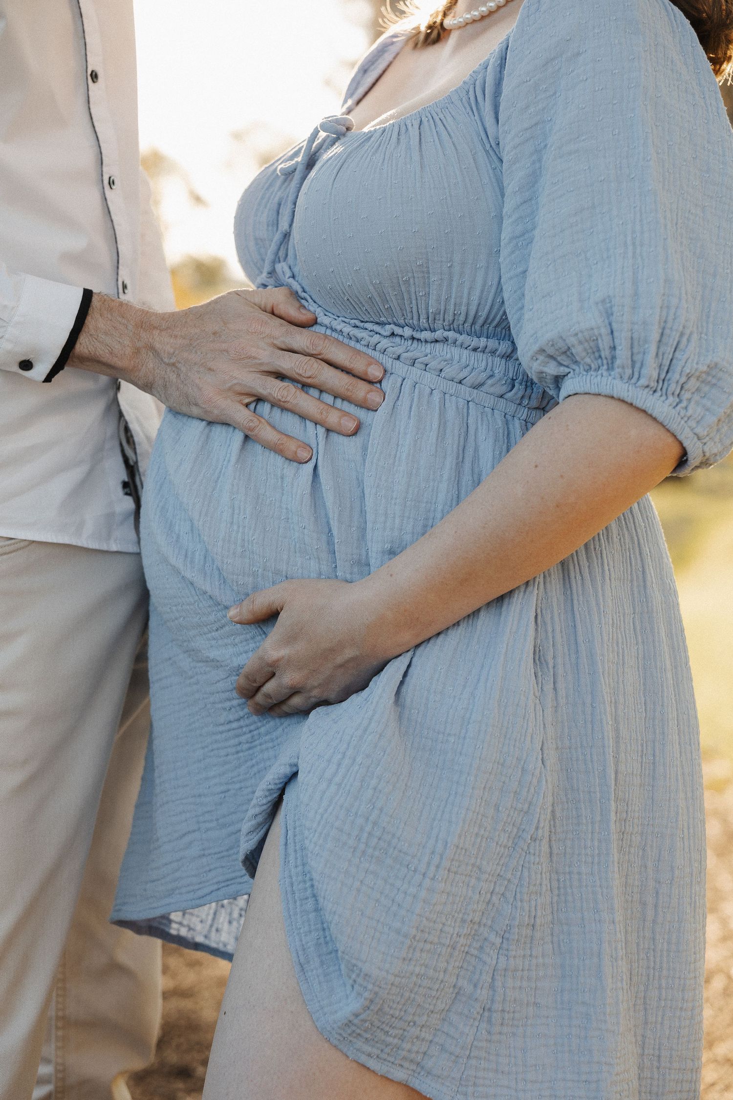 A couple cradling pregnant belly in maternity photoshoot outdoors in Canberra
