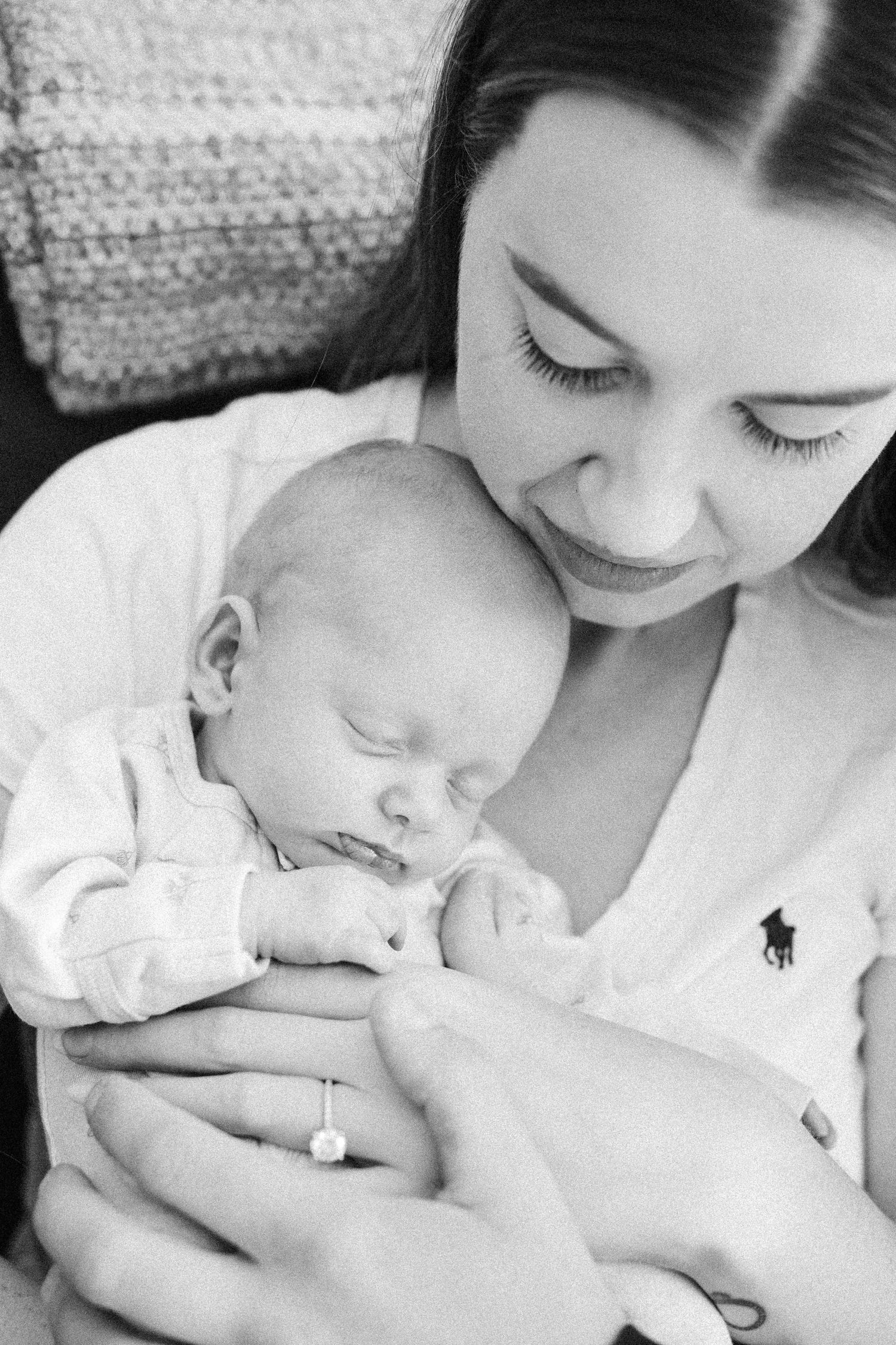 Black and white photograph of mother with her sleeping newborn baby in Canberra
