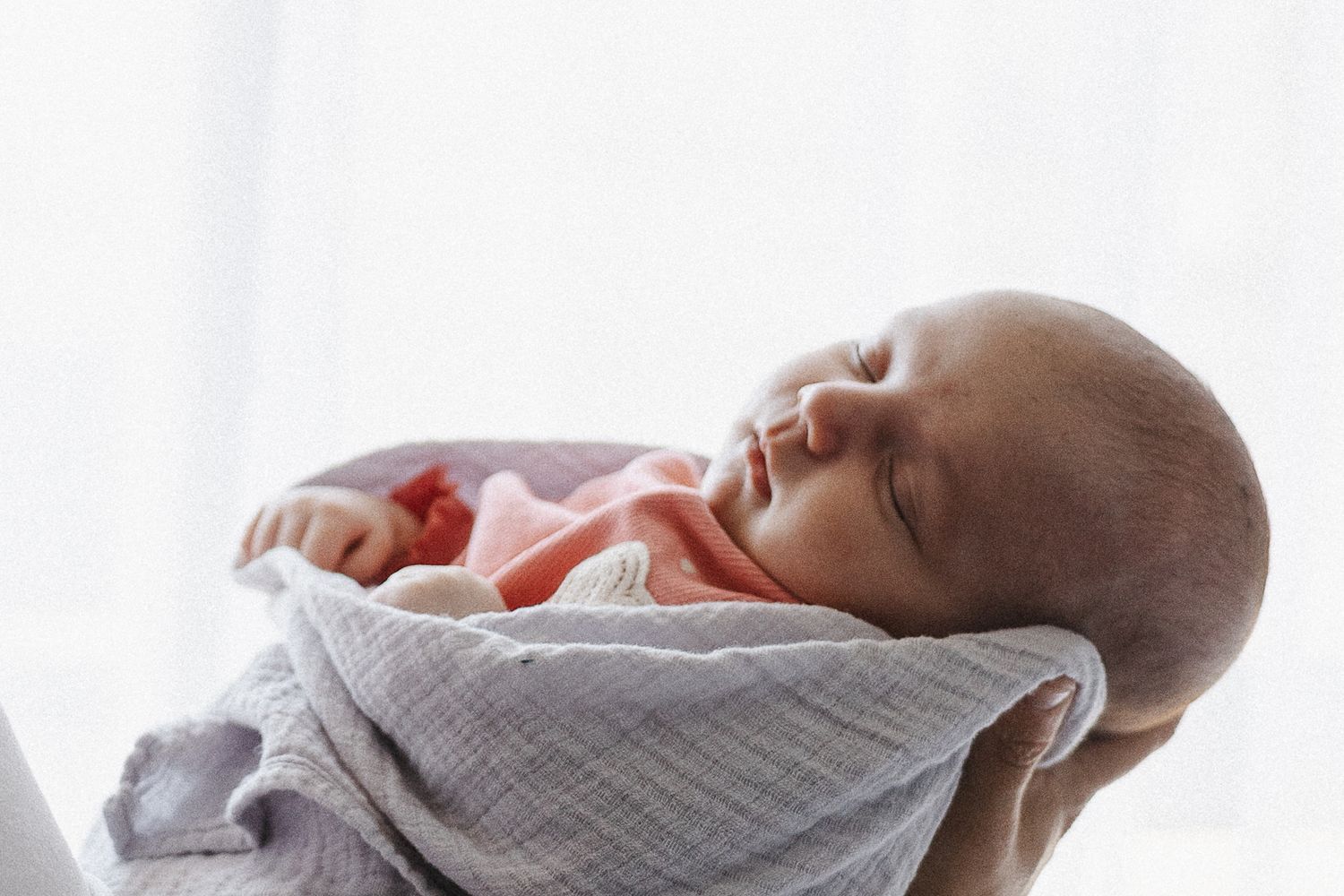 Sleeping baby held by mum in newborn photography studio Canberra