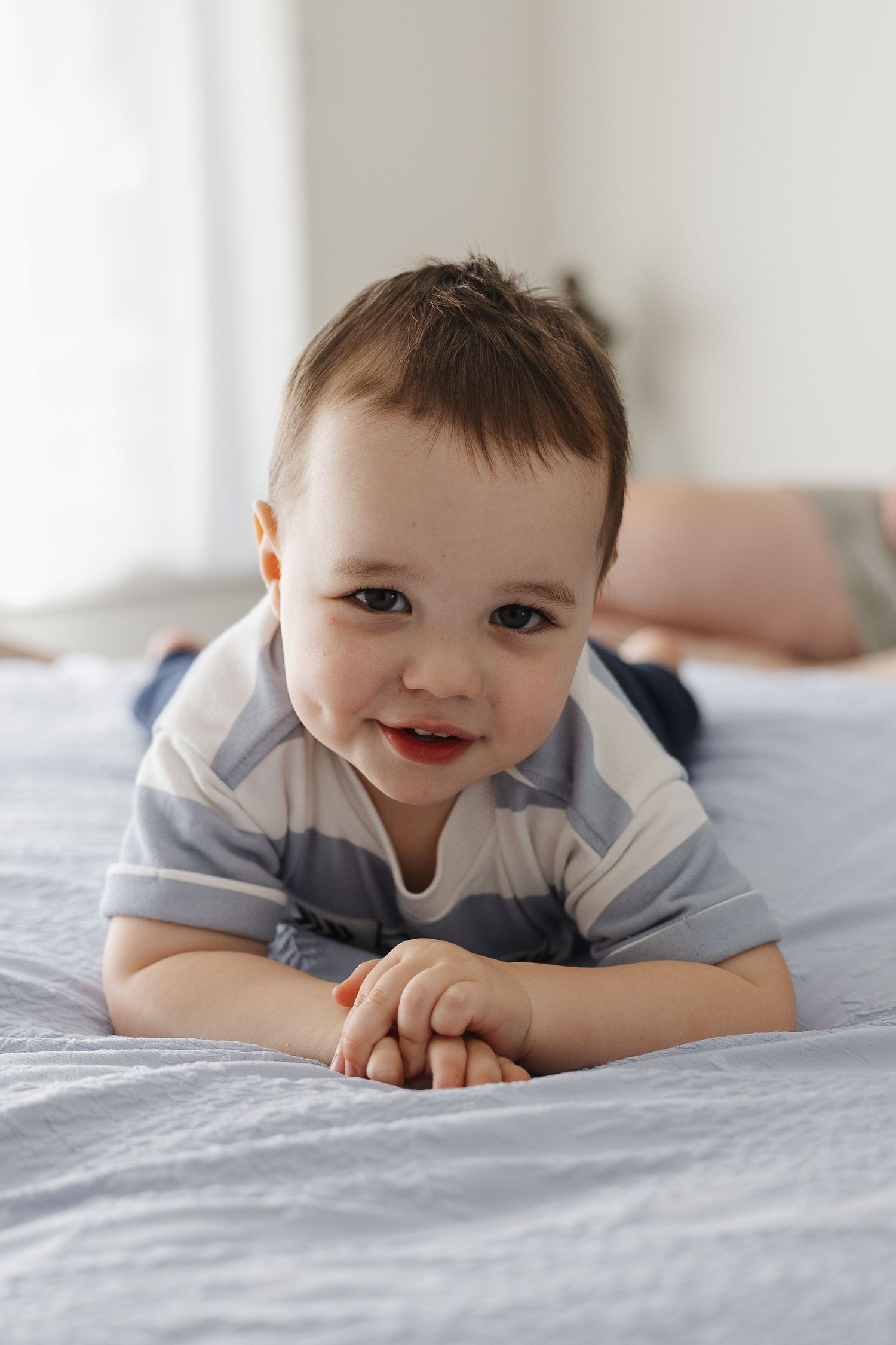 smiling toddler on the bed in a Canberra family photoshoot