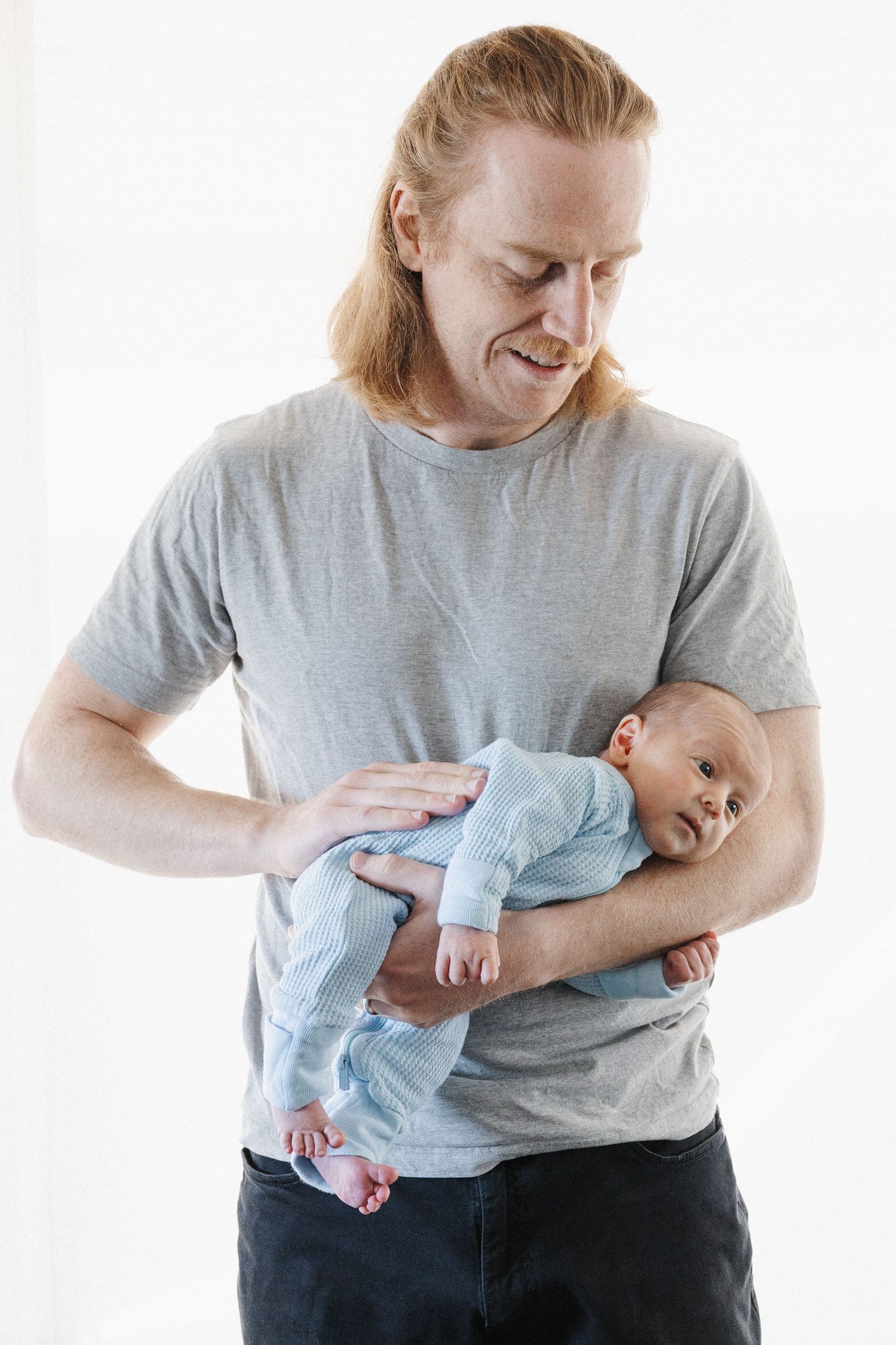Father rocks his newborn baby to sleep in Canberra