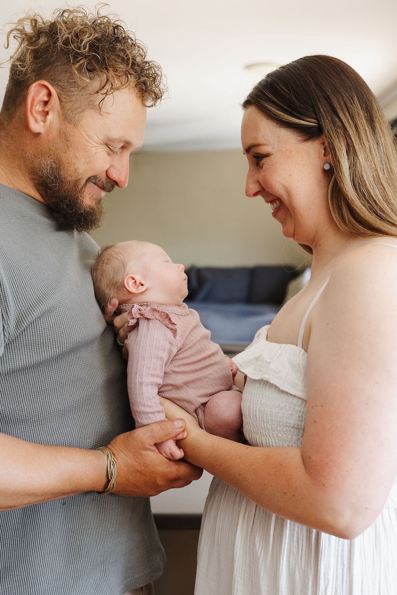 Couple look at their baby in newborn photoshoot Canberra