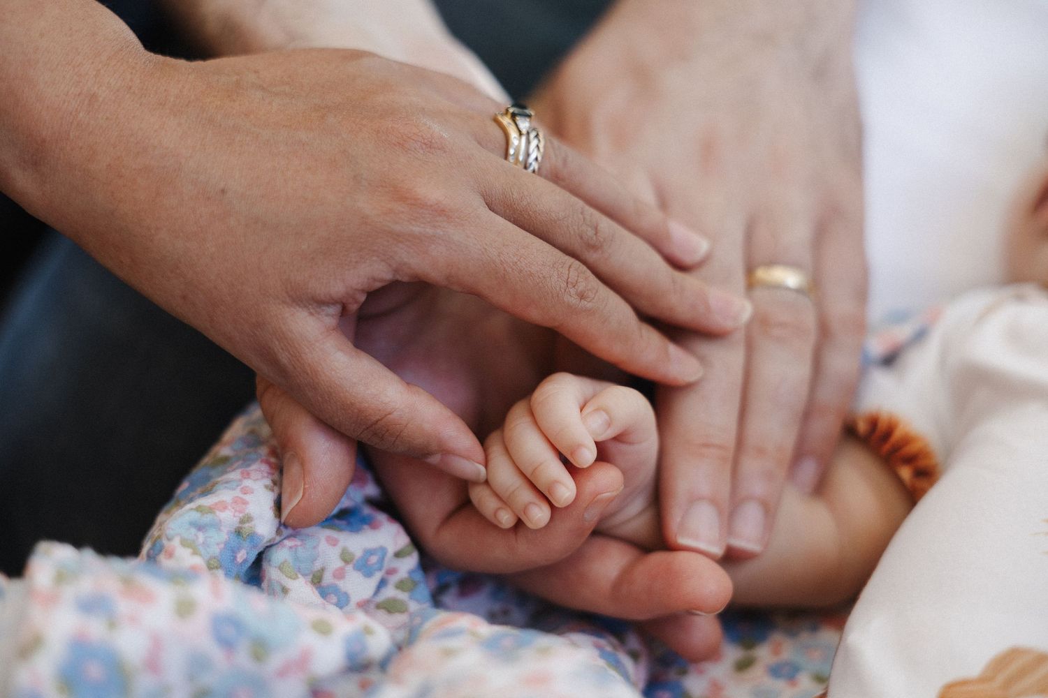 Two parents' hands hold their little baby's hand for a newborn photographer in Canberra