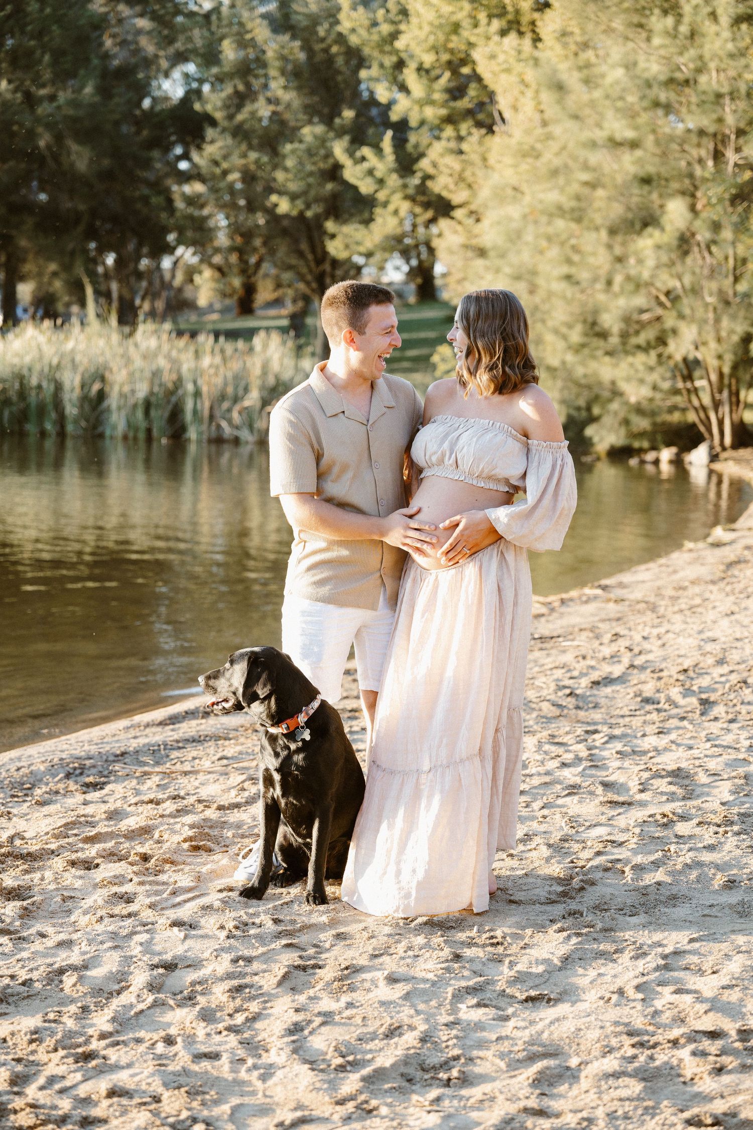 Pregnant couple on a beach with their dog in a maternity photoshoot in Canberra