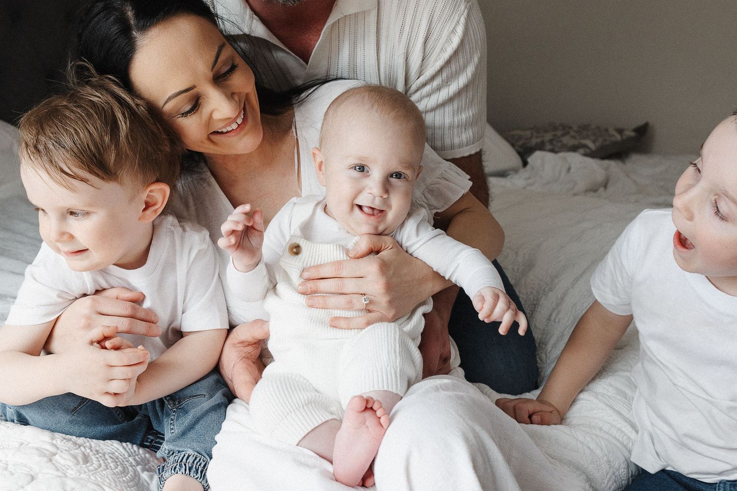A family plays on the bed in Canberra lifestyle family photoshoot