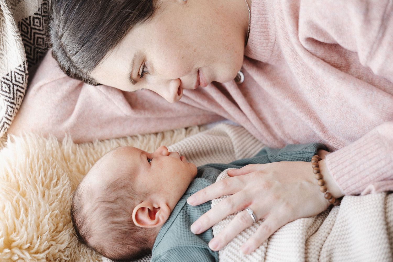 Mother lies next to newborn baby in Belconnen Canberra photography studio