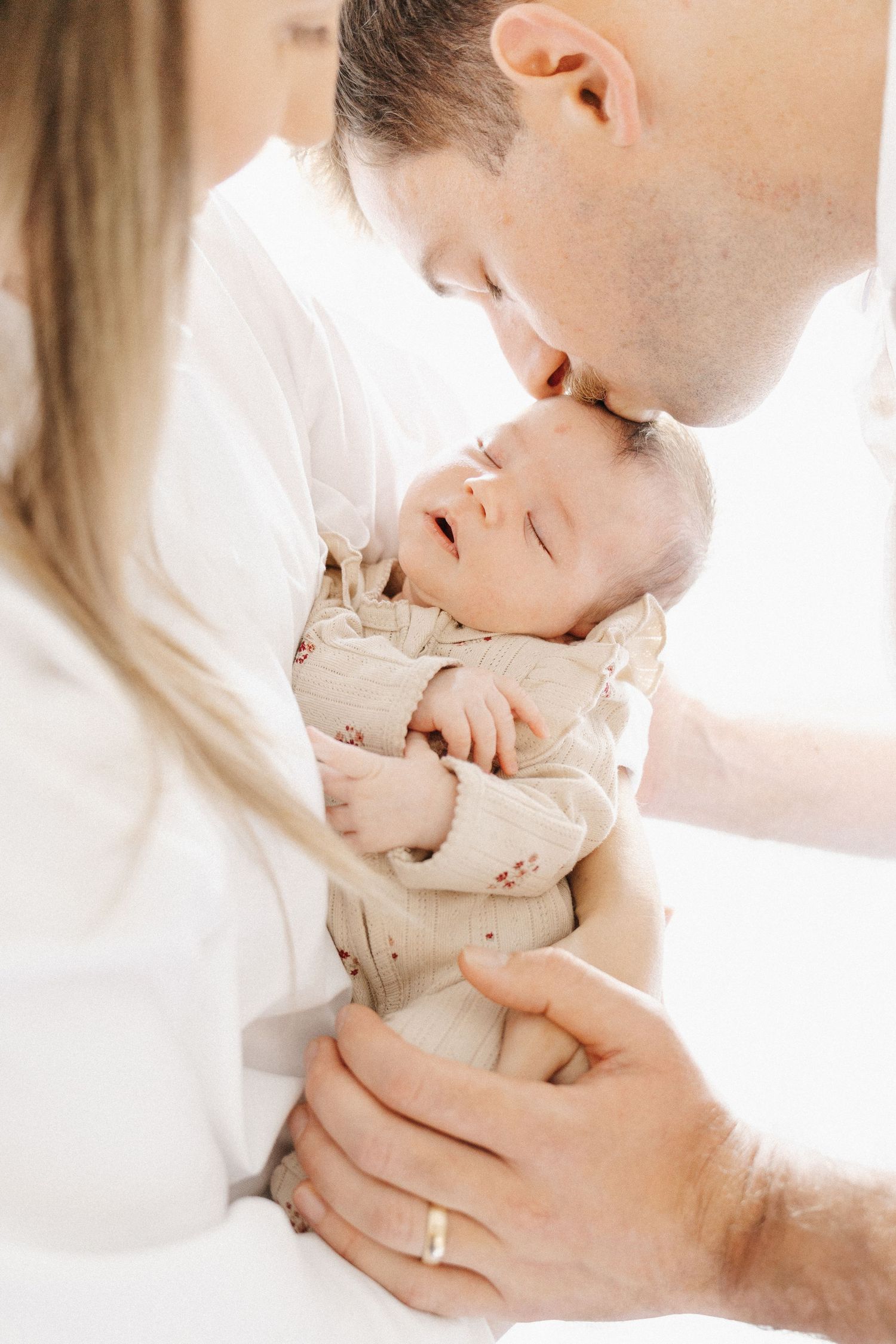Father kisses his newborn baby in Canberra