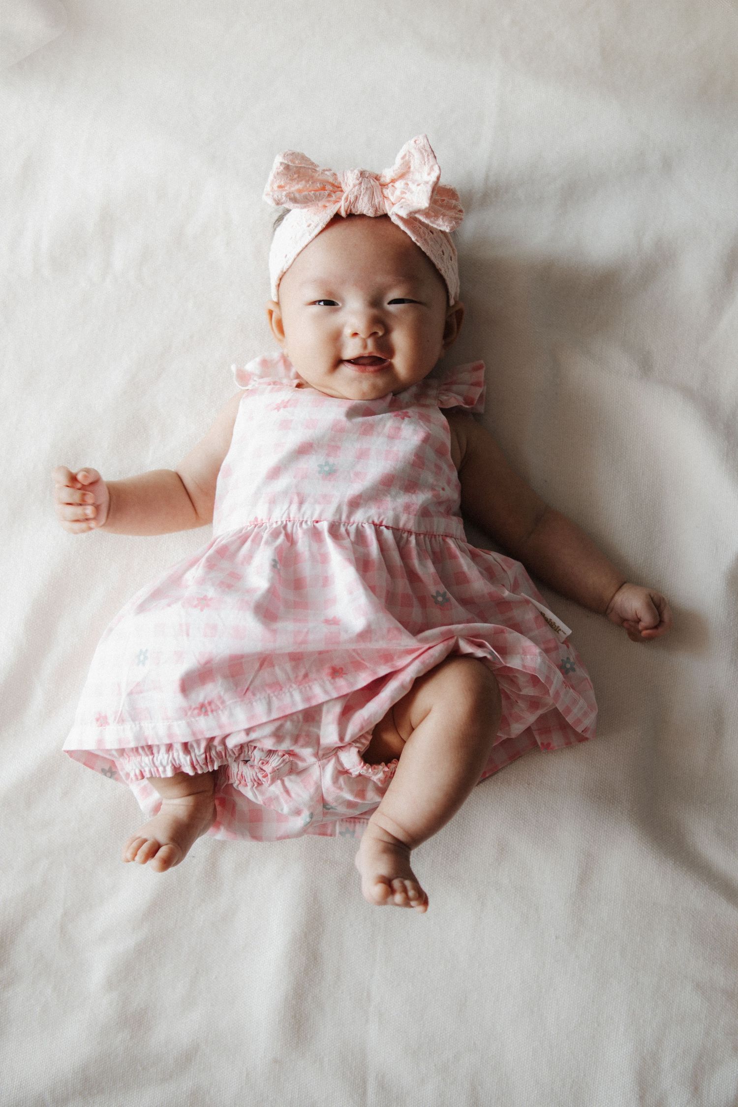 Happy baby girl photographed for 40 day milestone in Canberra with family photographer