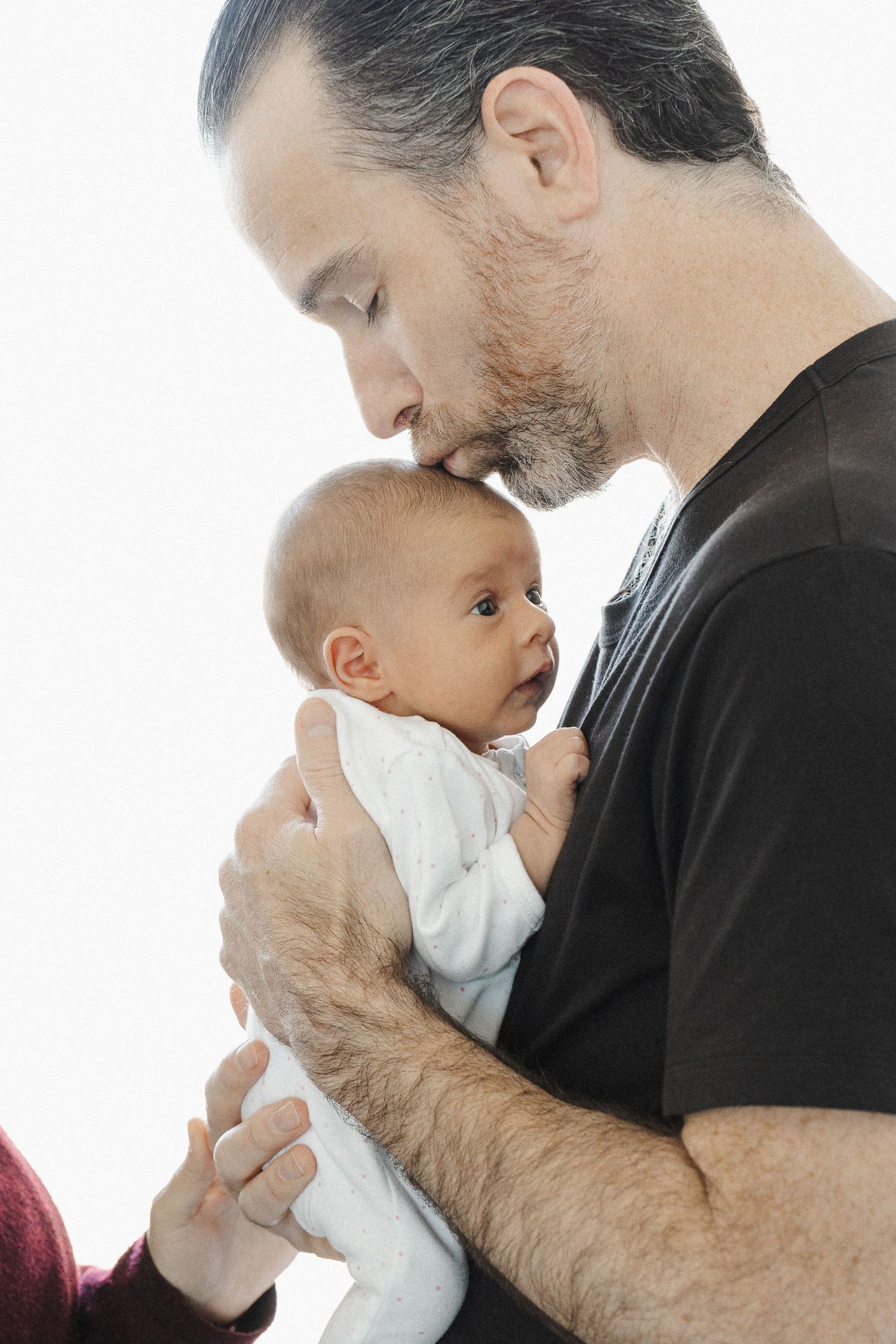 Father kisses his newborn baby in Canberra