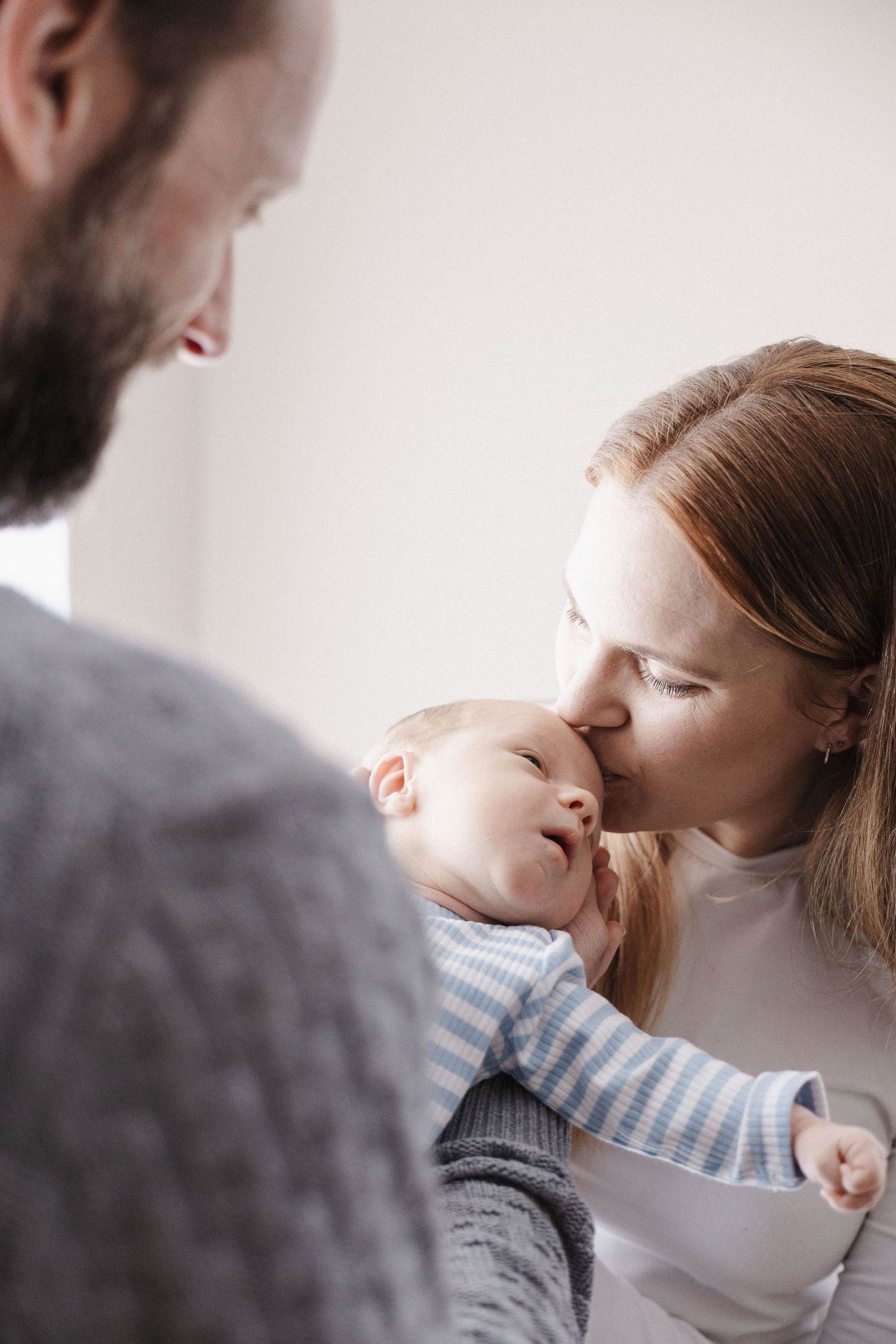 Mum kissing her baby in a newborn photo session in Canberra