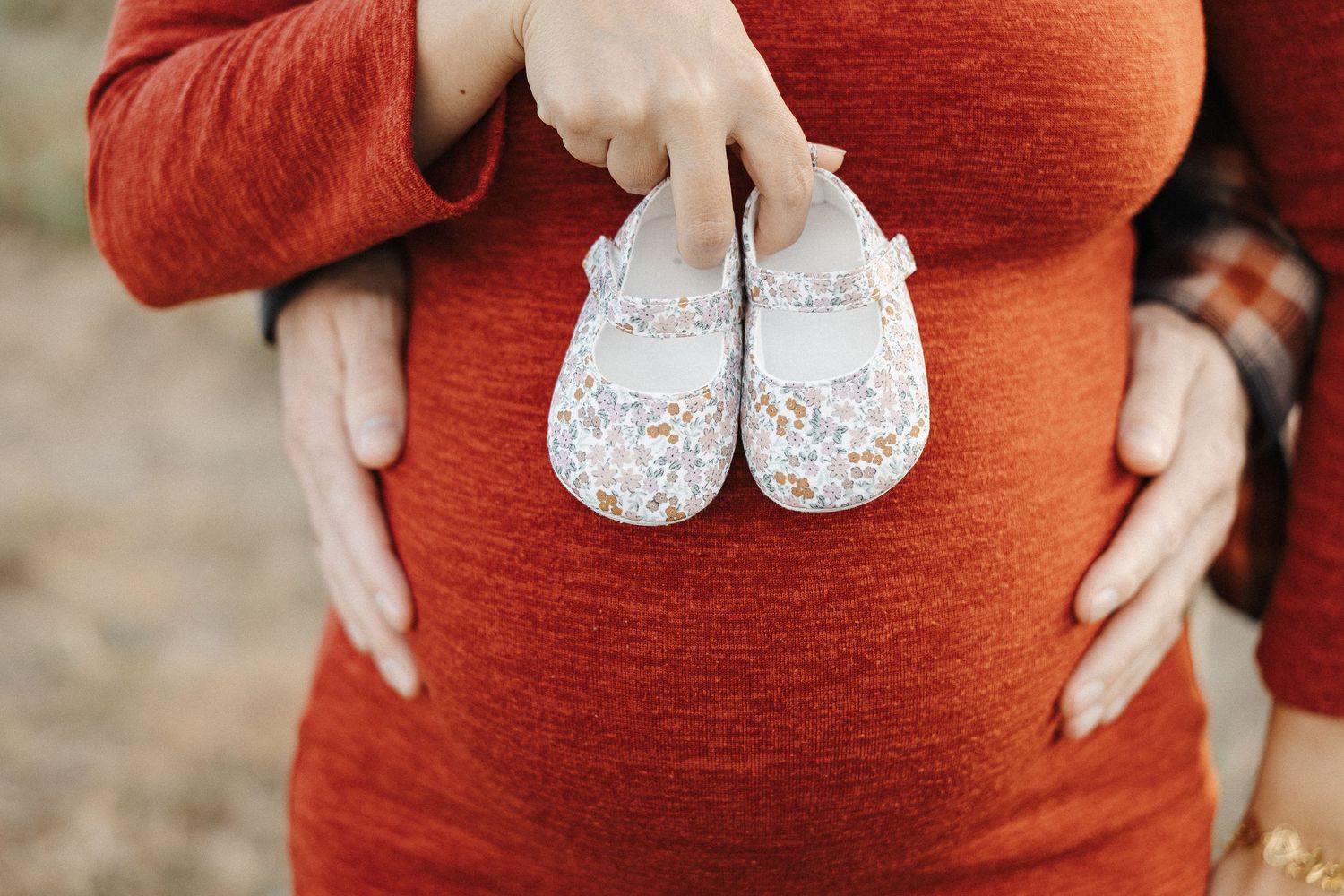 Two tiny shoes on a pregnant belly with Canberra maternity photographer Arboretum