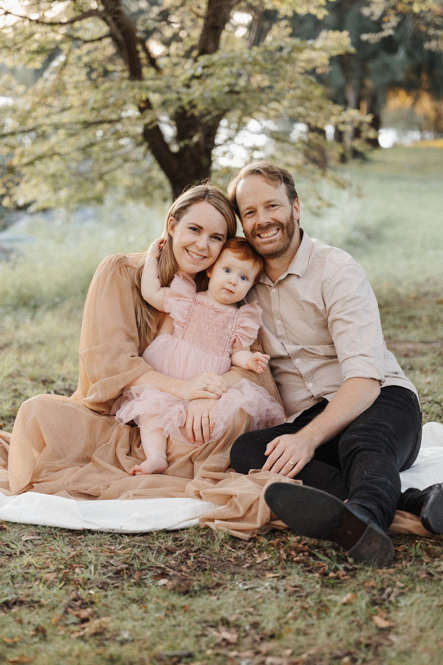 Happy family of three with cuddles in their family photoshoot in Canberra