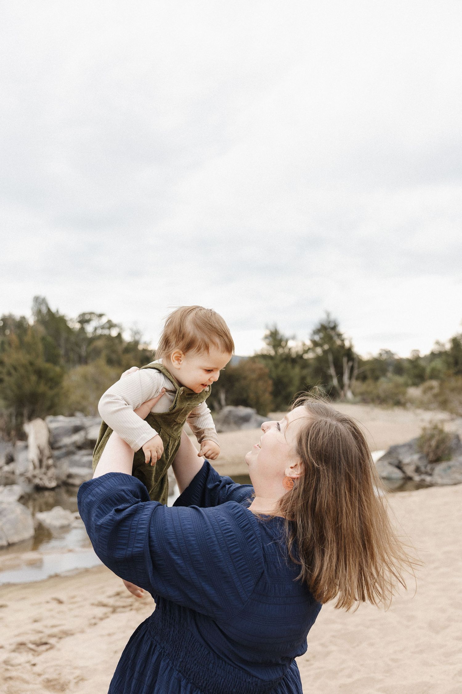 Toddler smiles at his mum in a Canberra family photoshoot outdoors