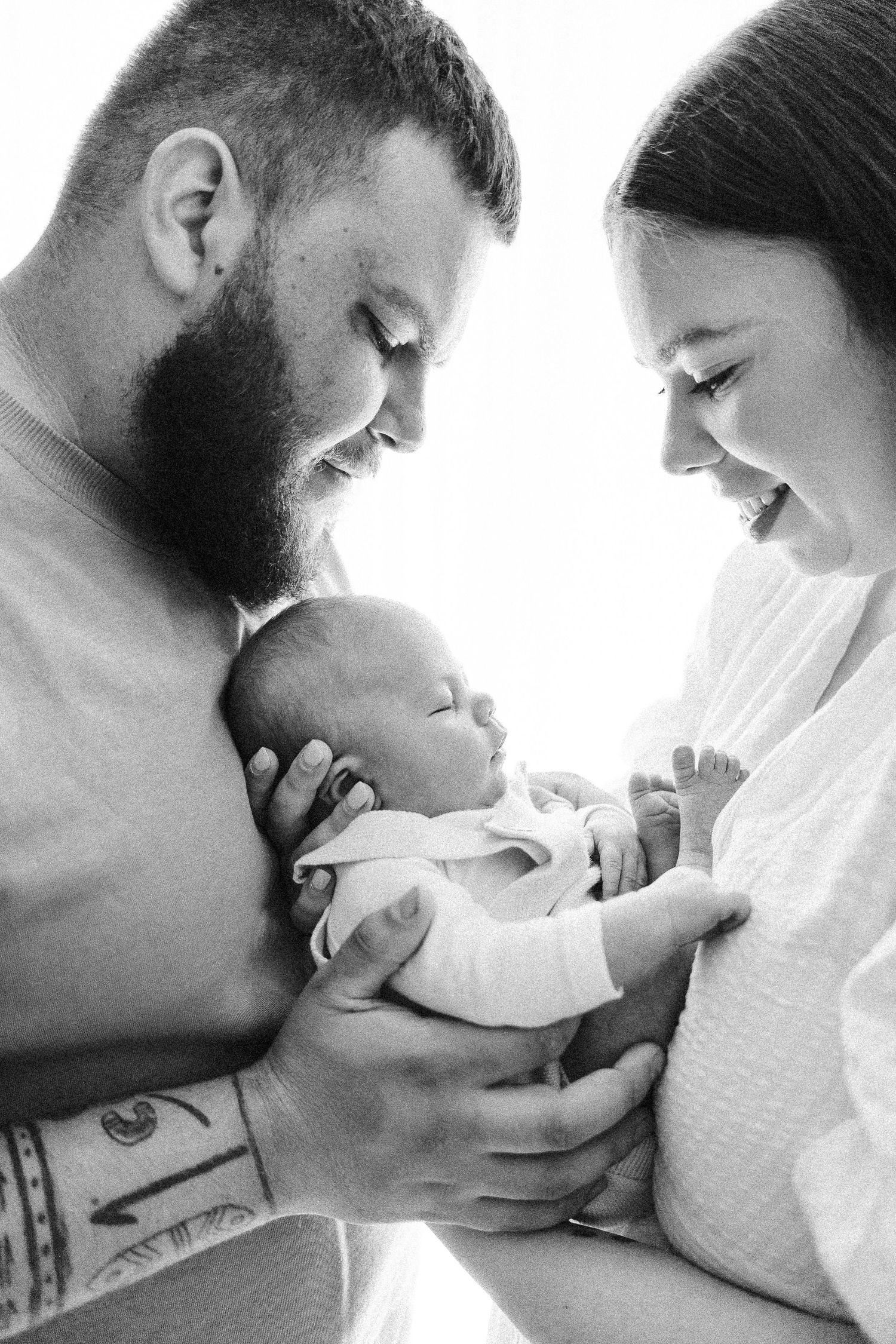 Black and white backlit portrait of parents with their newborn baby in Canberra studio