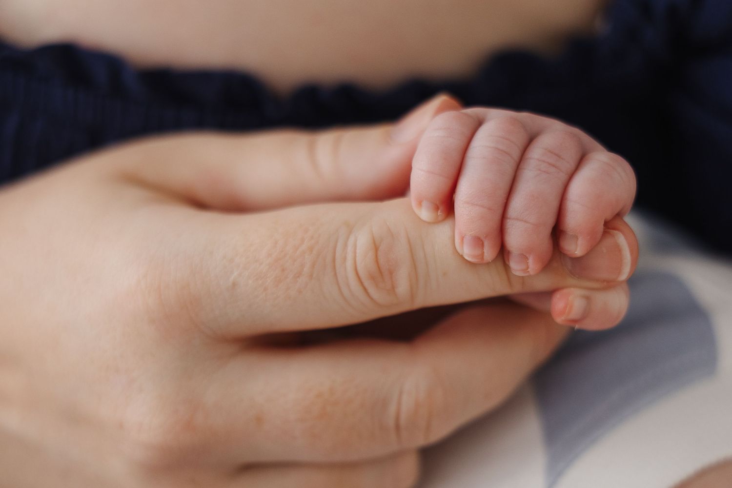 baby fingers curled around mum's finger in Canberra newborn photoshoot