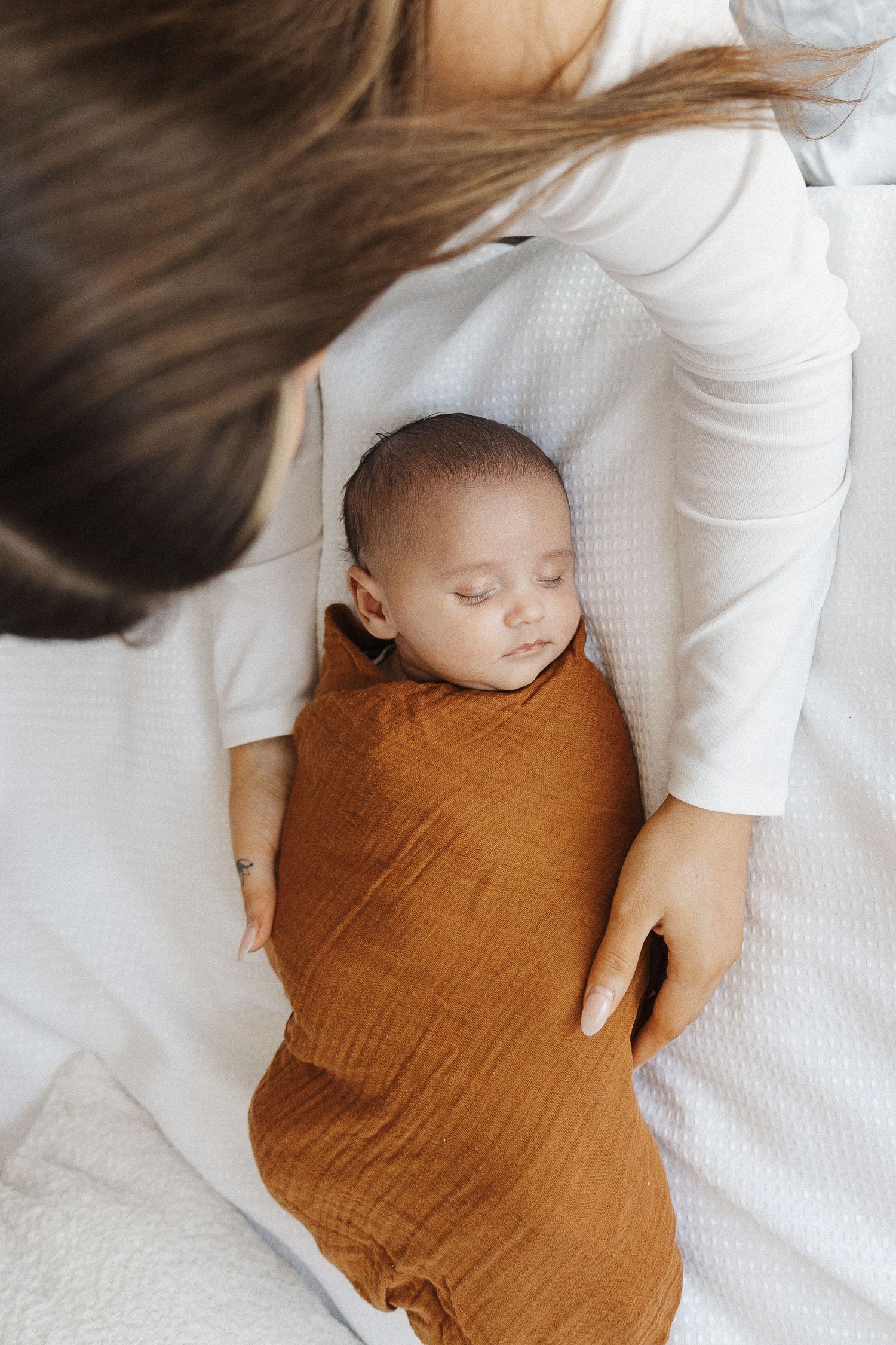 Mother looks over her newborn baby sleeping in Belconnen Canberra photography studio
