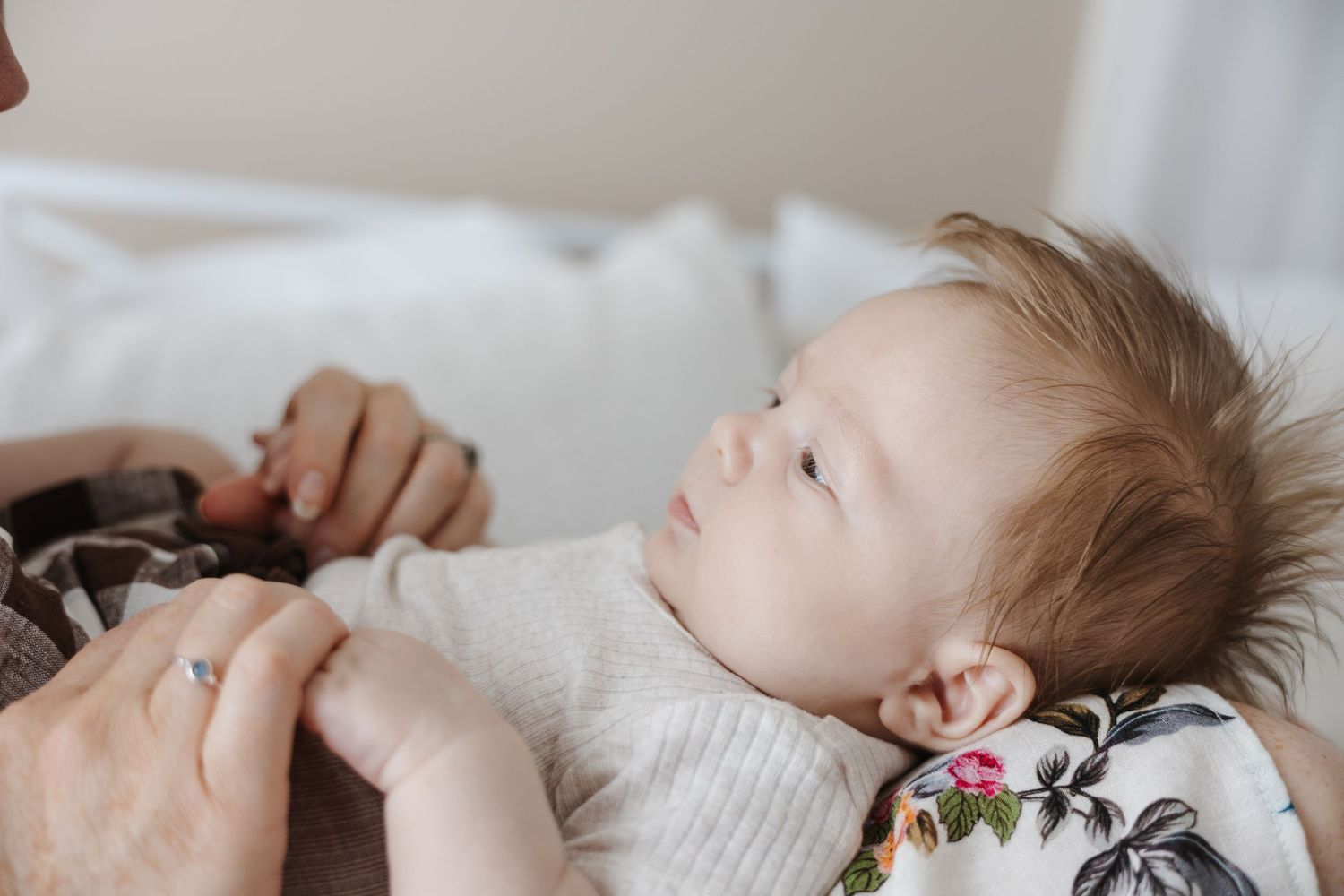 A newborn baby boy is photographed looking at his mother in a Canberra photo studio
