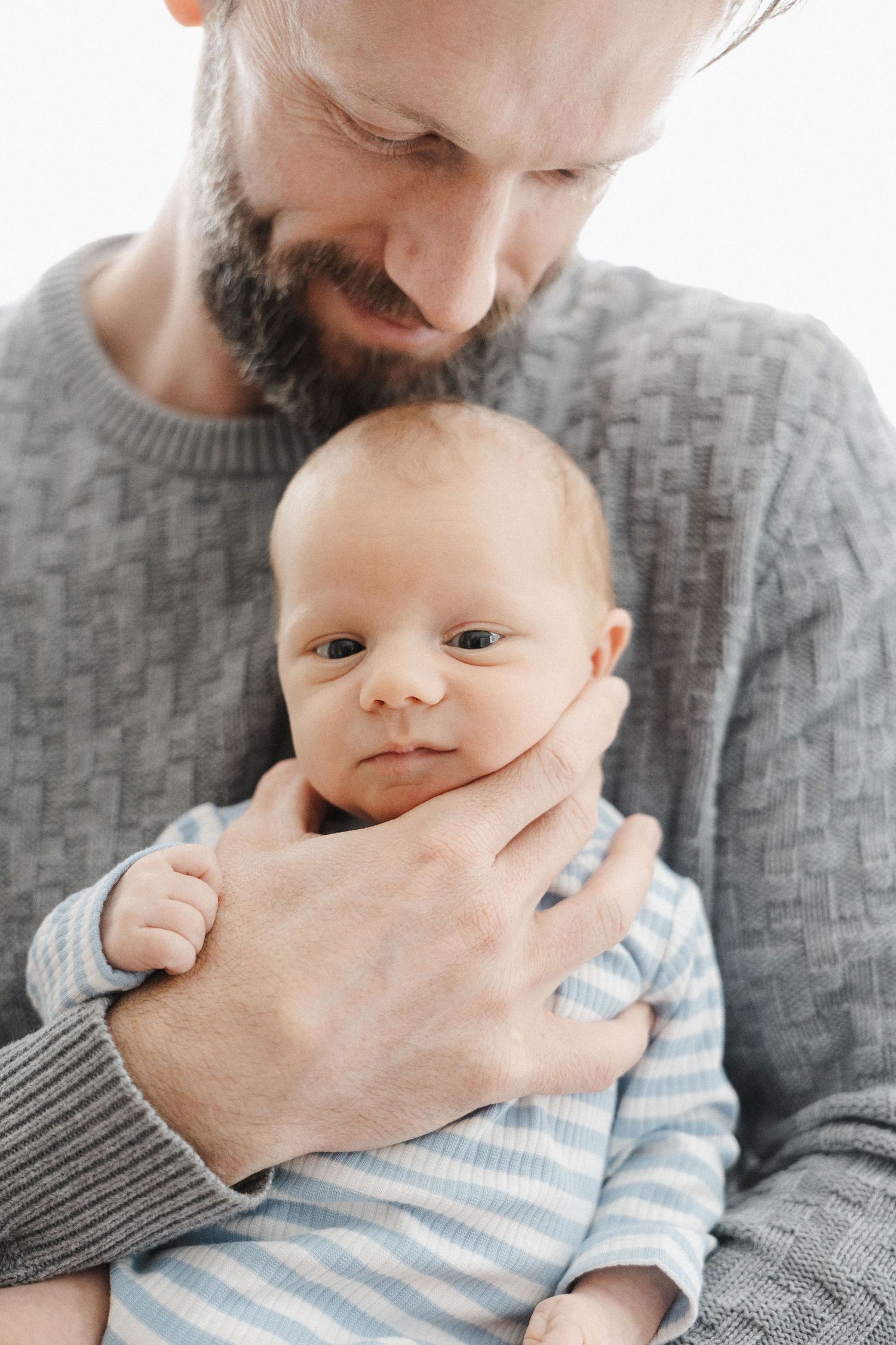 Dad holding his newborn baby in Canberra photo studio