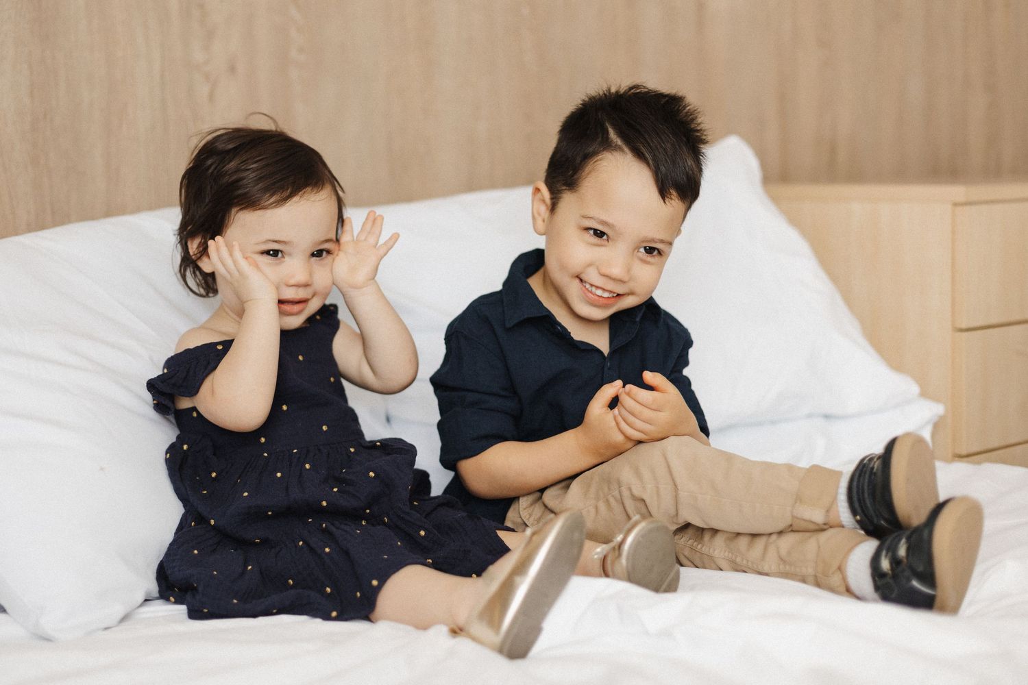 Two cute kids sitting in bed with family photographer Canberra
