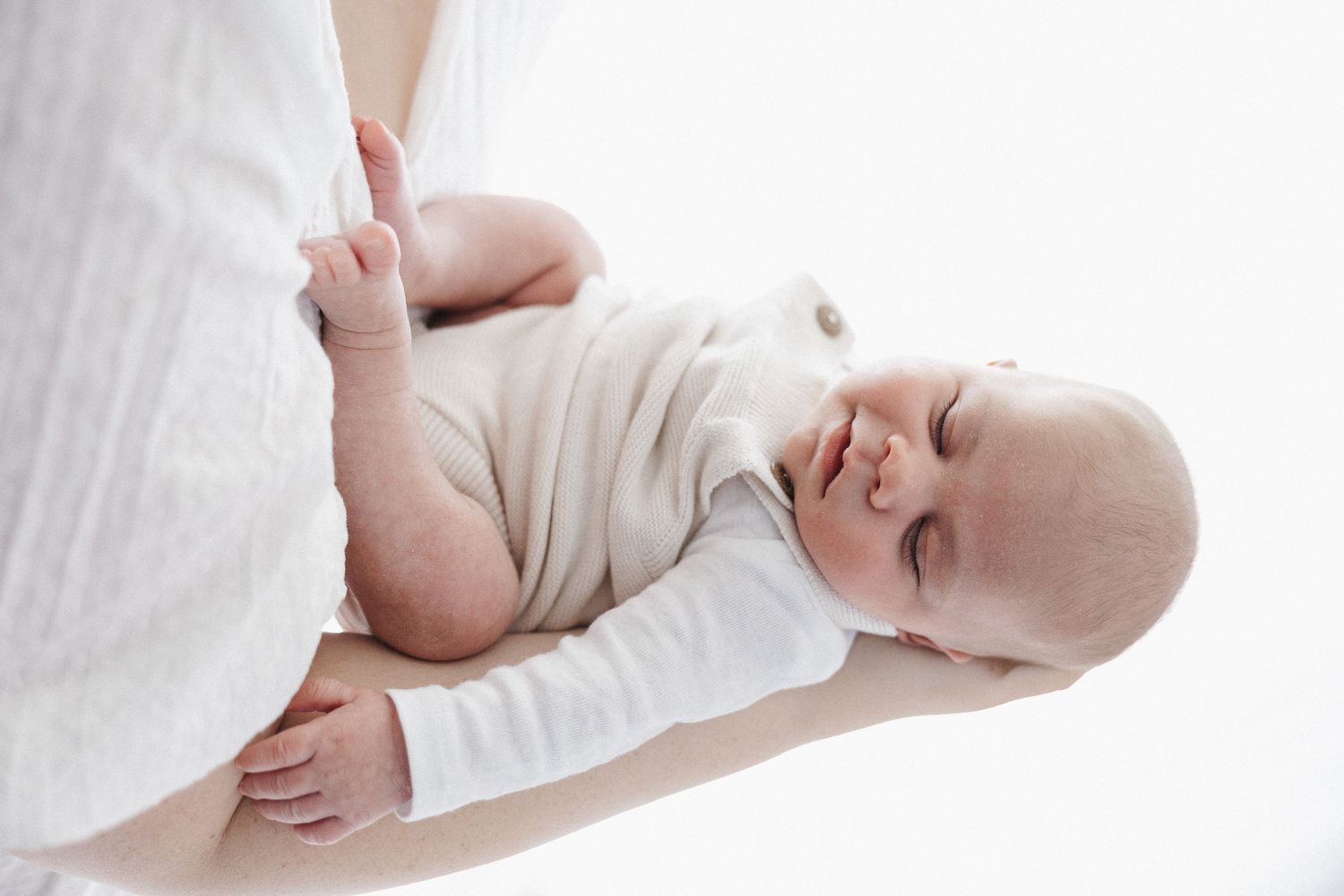 A baby sleeps on his mother's forearm in Canberra studio newborn photoshoot