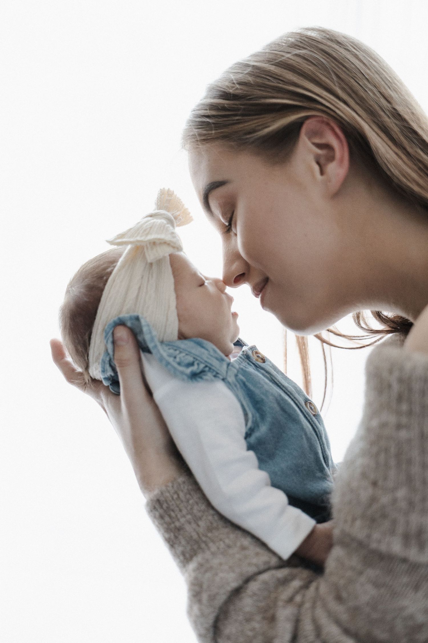 Mother brushes noses with her newborn baby in Belconnen Canberra photography studio