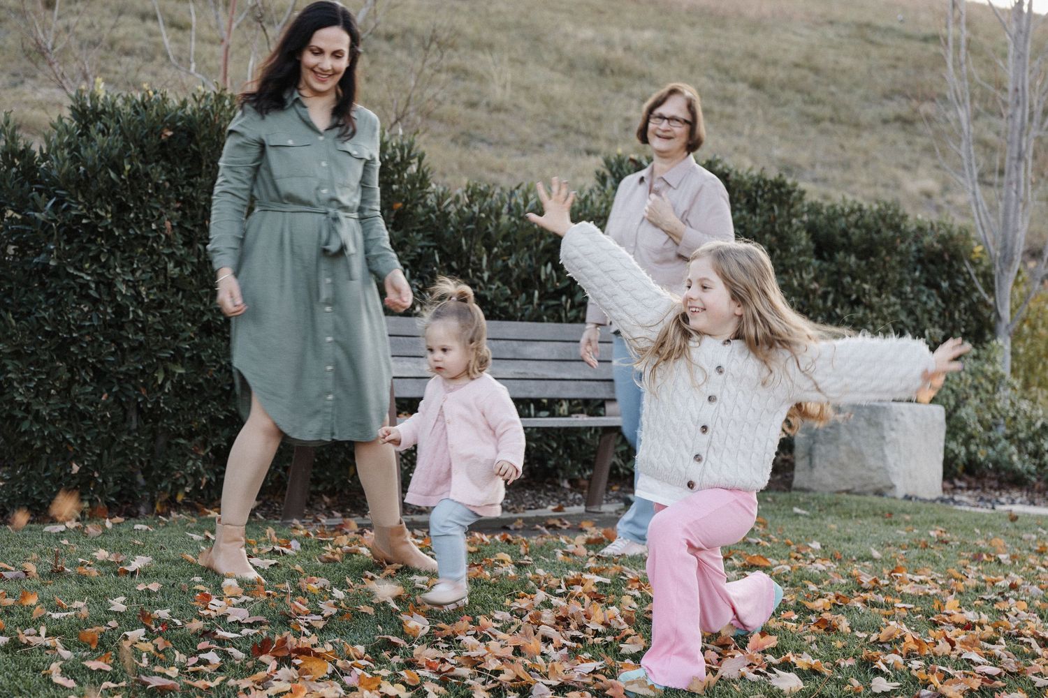 family photo playing in autumn leaves in Canberra Arboretum