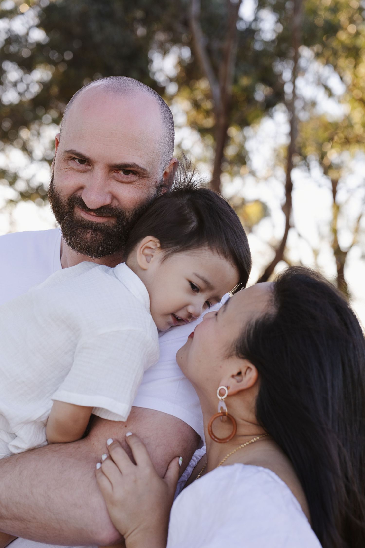 Toddler snuggles mum and dad in Canberra family photo session