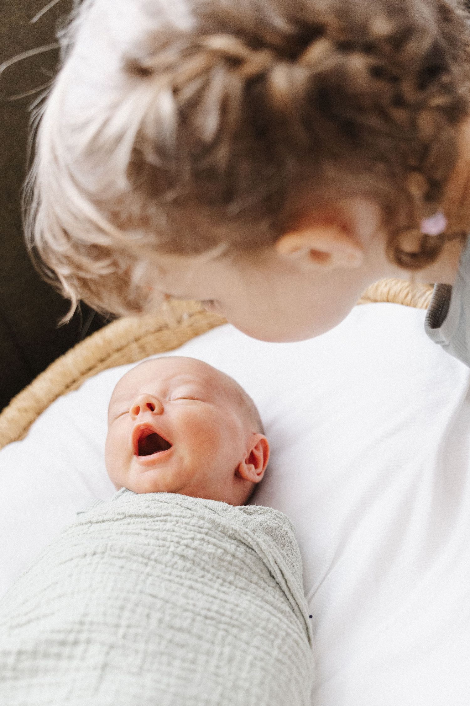 Sister looks over her baby brother in newborn photoshoot Canberra