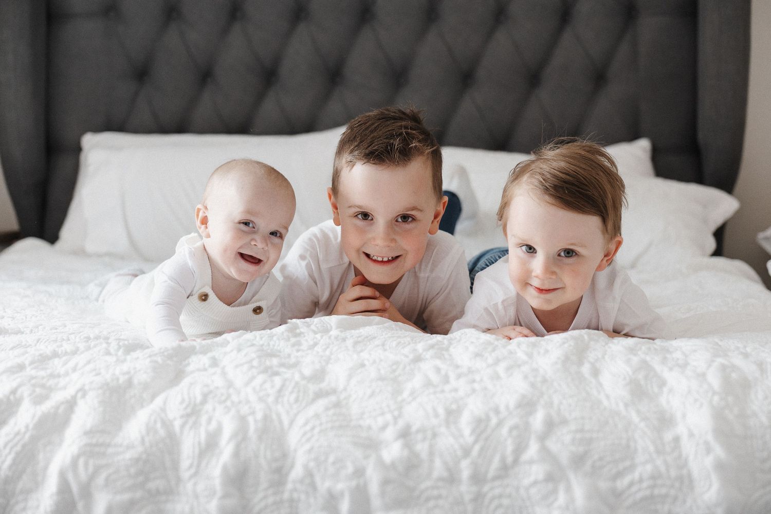 Three boys pose on the bed in their in home lifestyle family photoshoot in Canberra