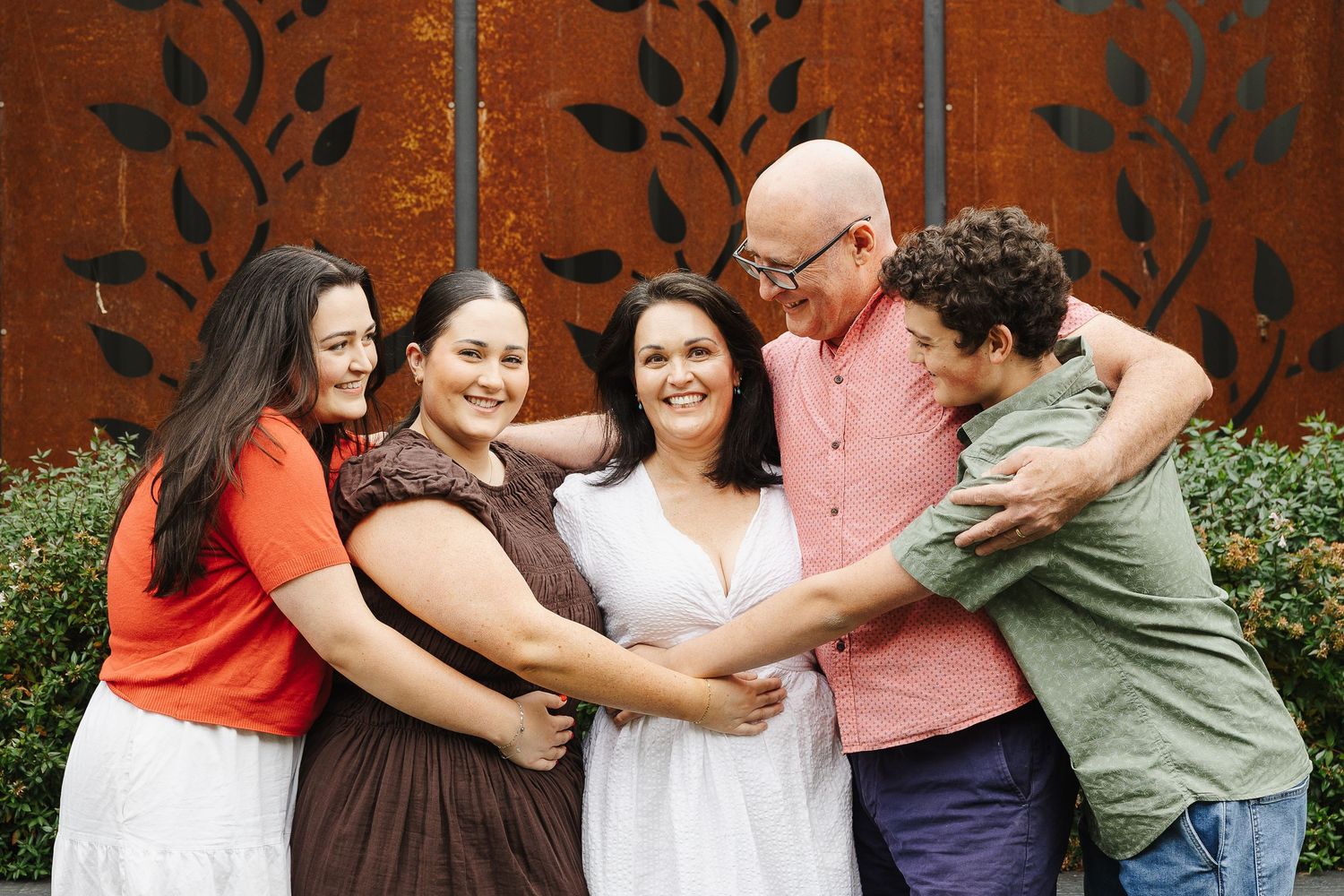A Canberra family hugs and laughs during an in home family photo session