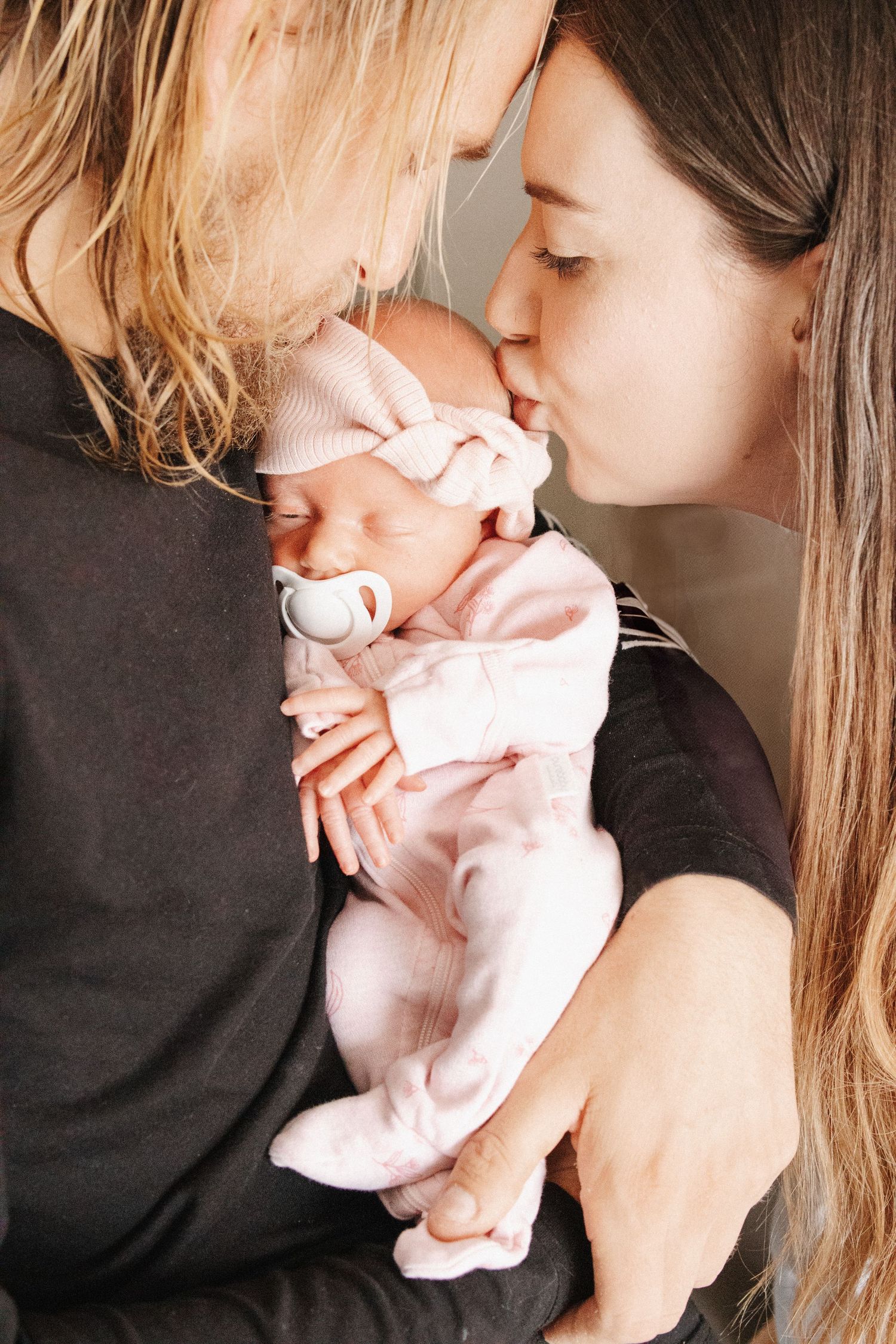 Parents kiss their newborn baby in Canberra