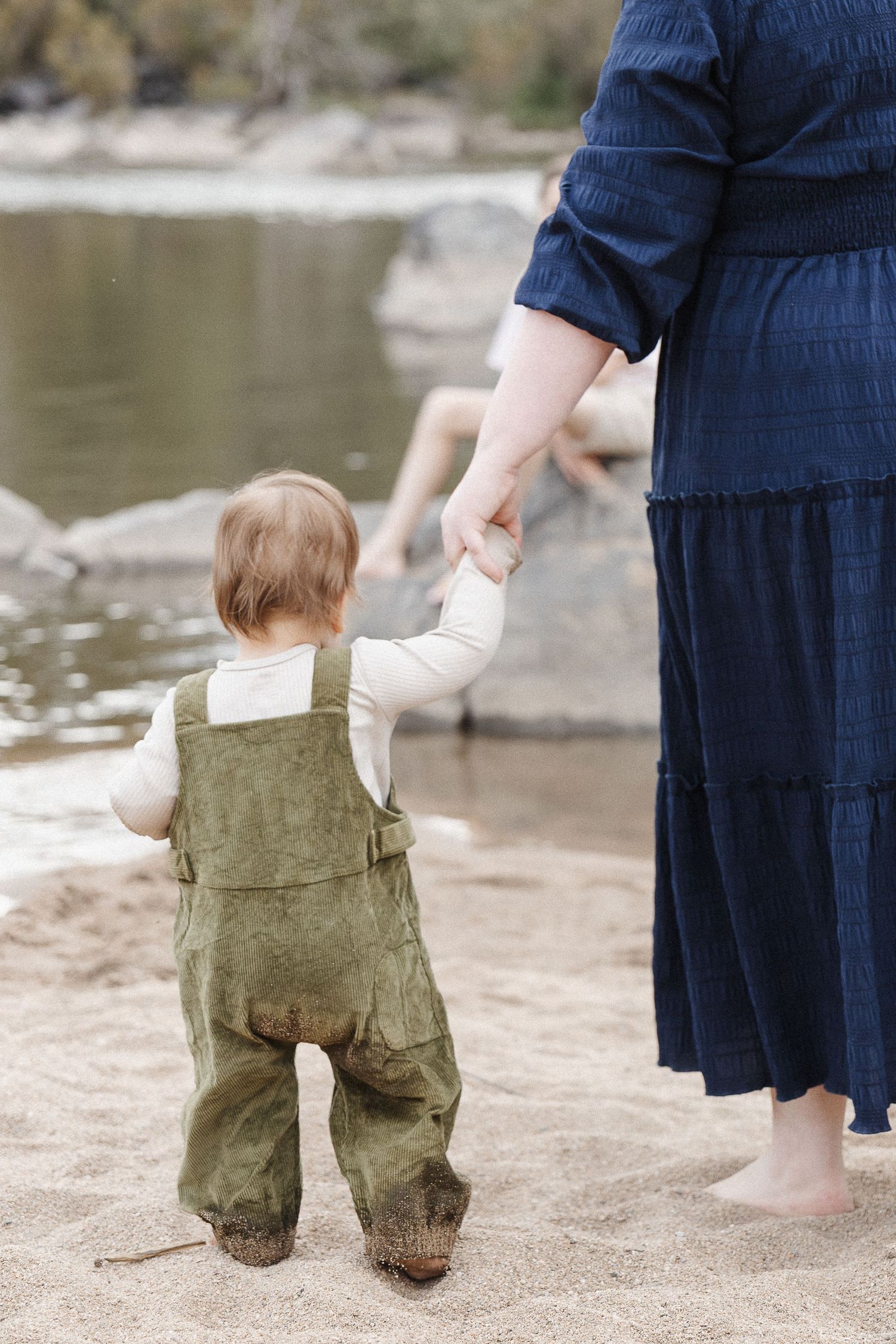 Toddler walks holding his mum's hand in a Canberra family photoshoot