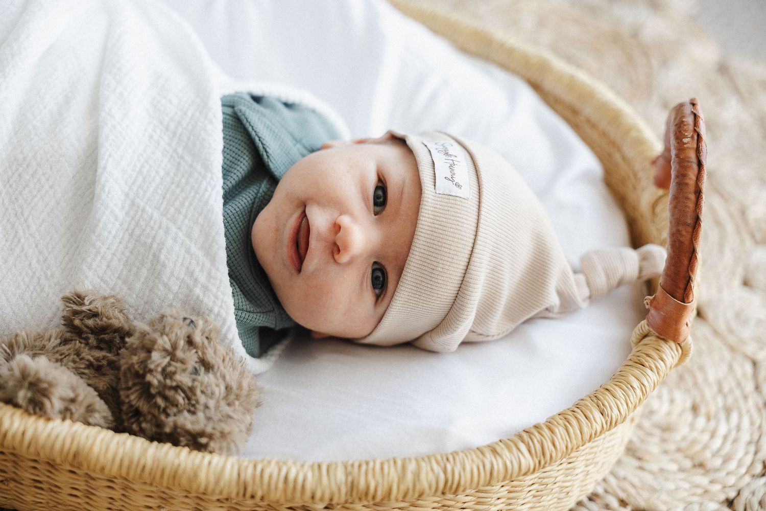 Smiling newborn baby boy with hat in Belconnen Canberra photography studio