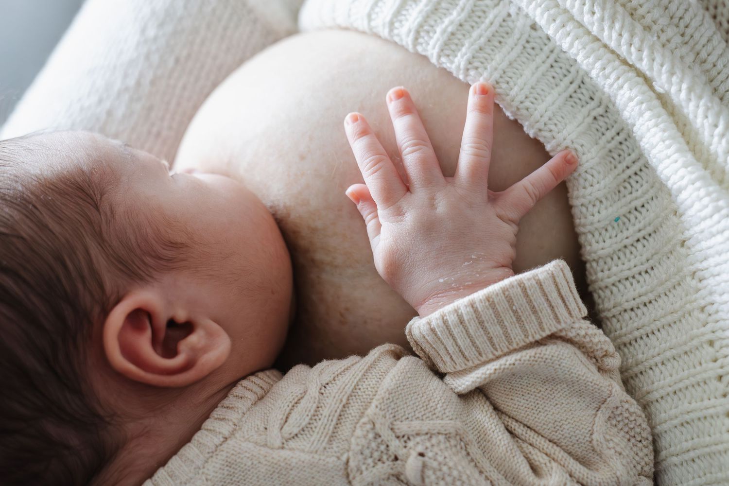 breastfeeding baby and his little hand in a Canberra in home newborn photoshoot