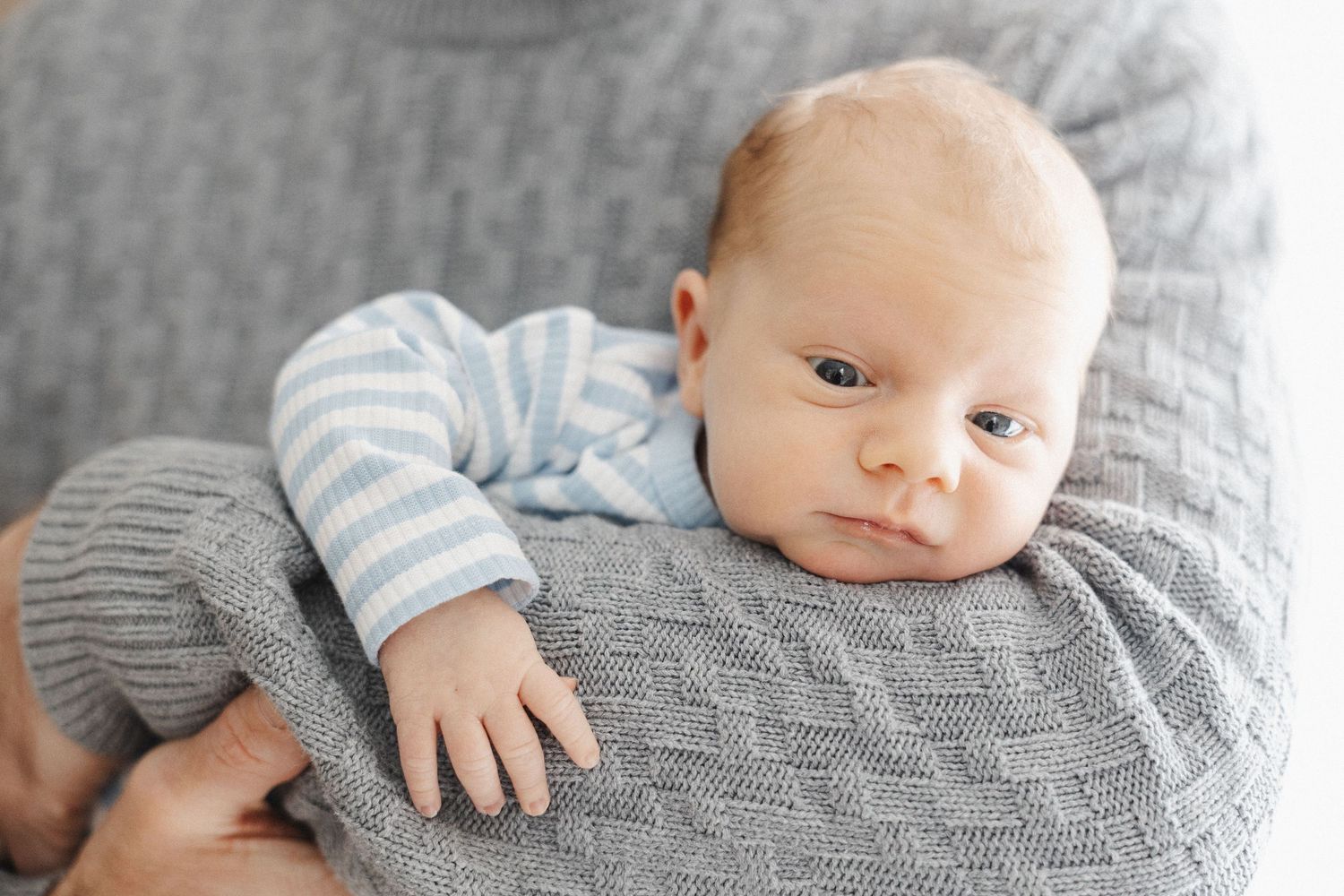 baby snuggling in his dad's elbow in Canberra newborn photo session