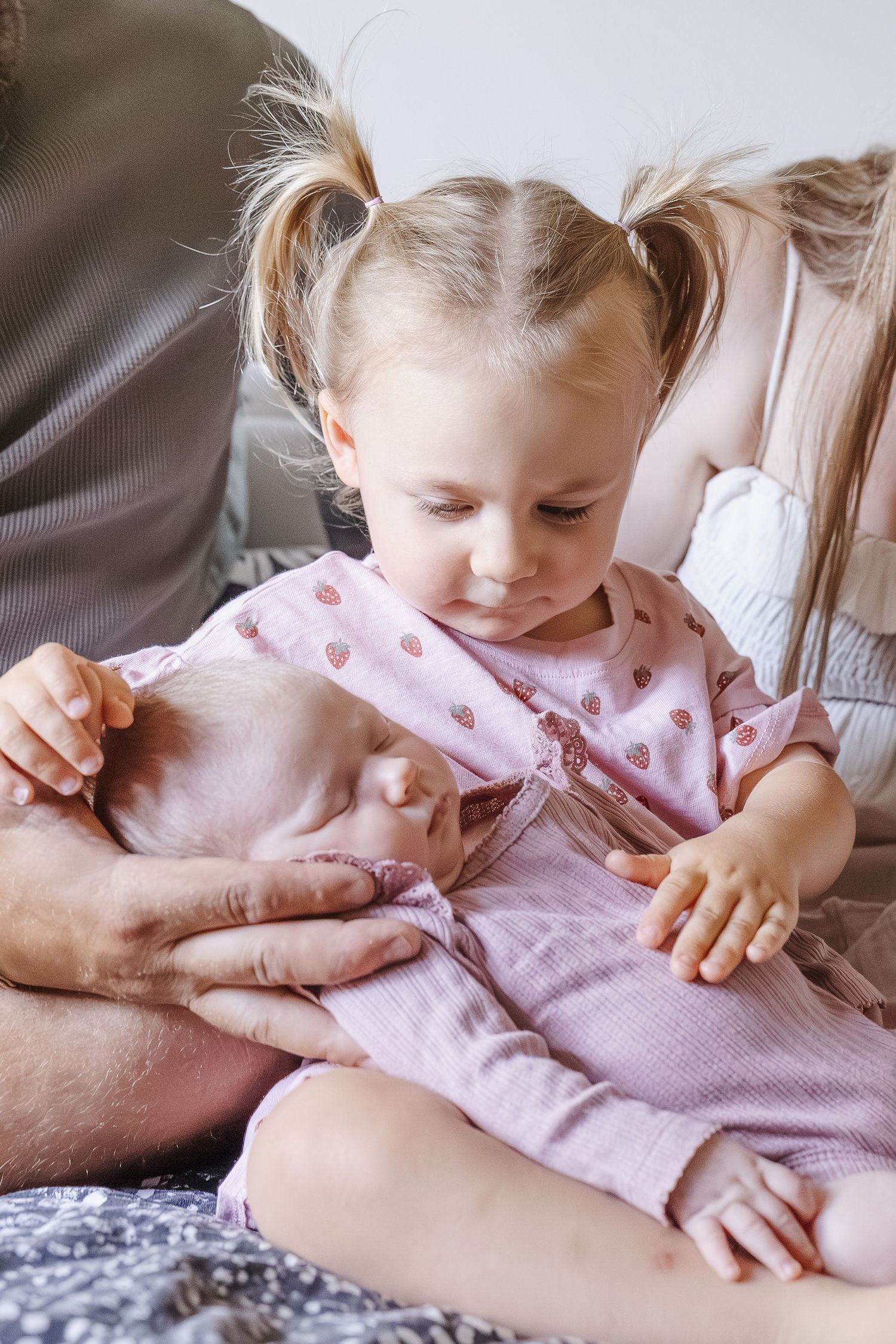 Toddler holds her baby sister in newborn photoshoot Canberra