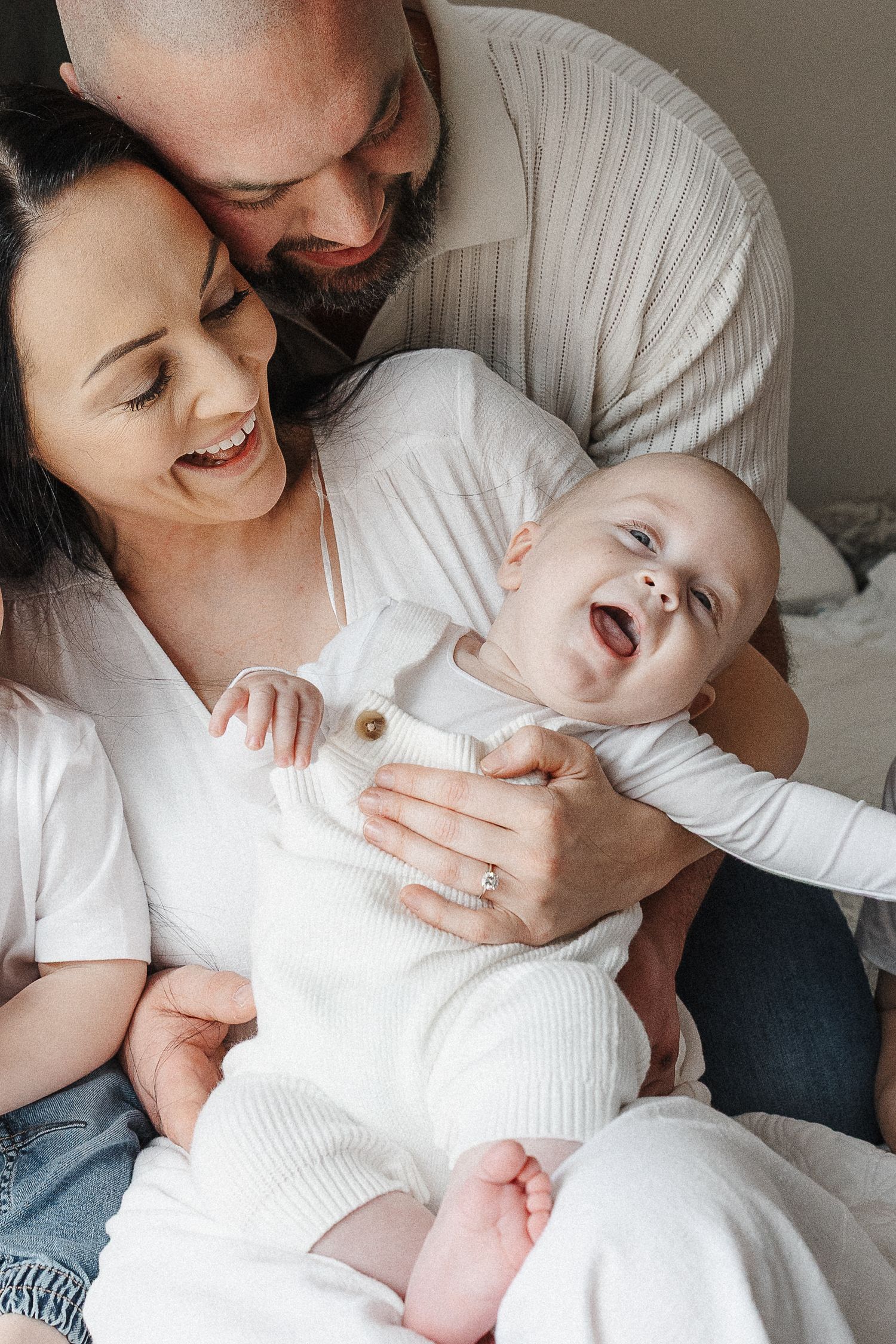 Laughing baby with mum and dad in their Canberra home relaxed family photoshoot