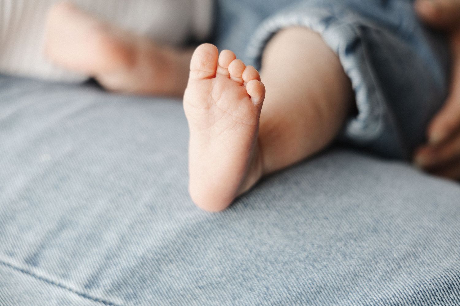 A little baby foot on denim jeans in Belconnen Canberra photography studio