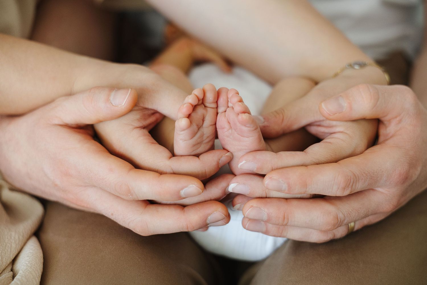 Mother and father hold baby's feet in newborn photoshoot Canberra