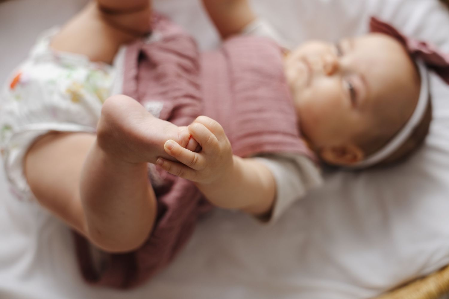 Six month old baby grabs her foot in Canberra baby photoshoot