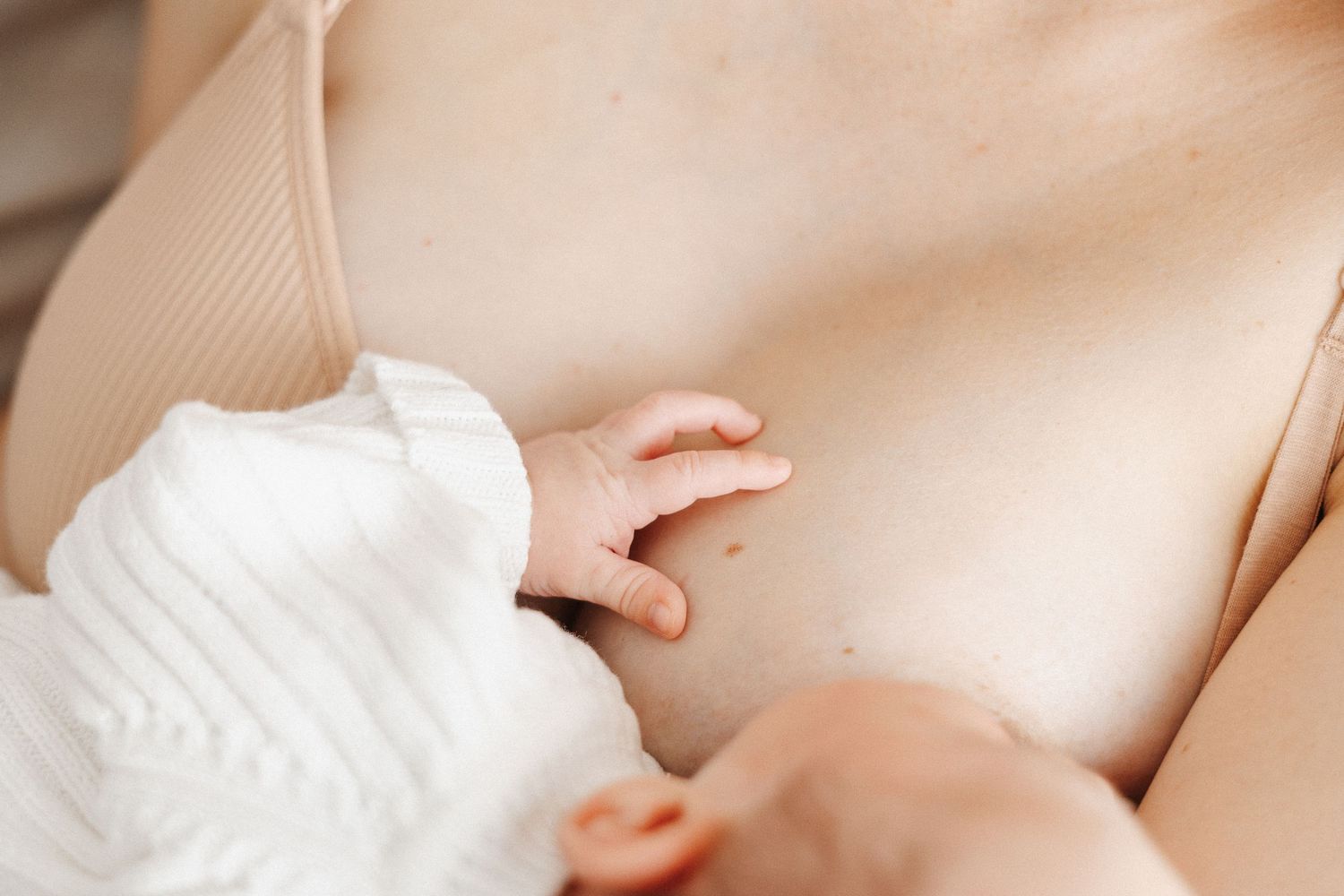 Newborn baby breastfeeding with little hand in Canberra