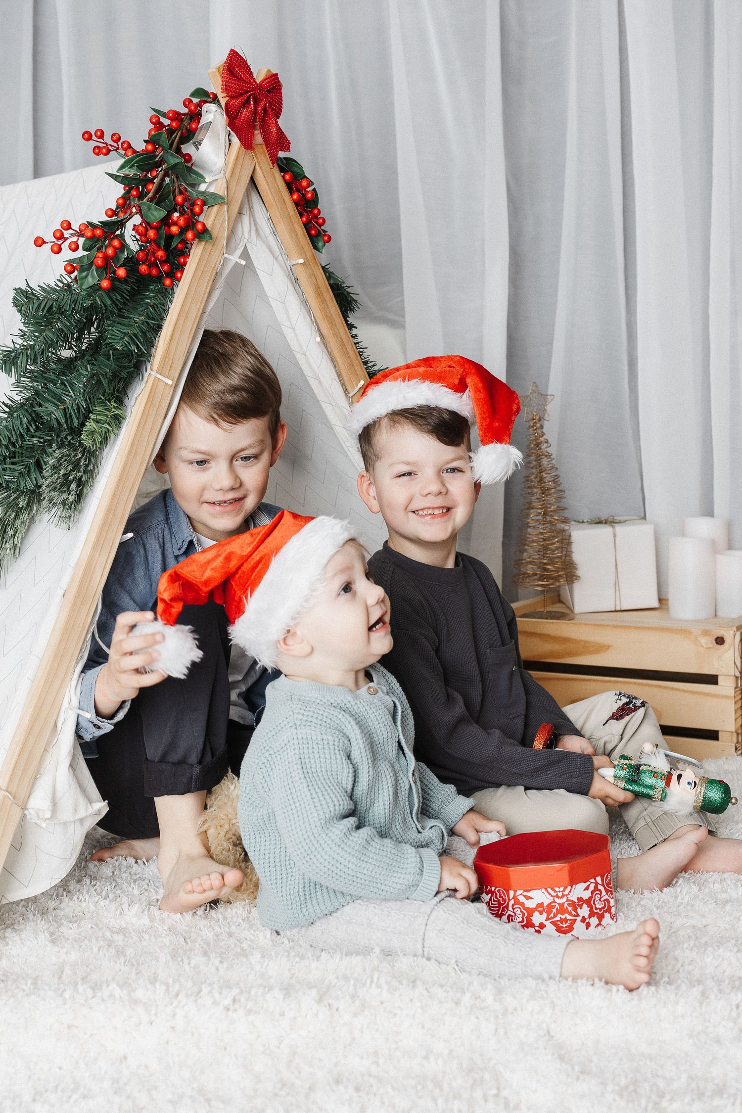 Three boys with santa hats in a tent in Canberra Christmas mini photoshoot