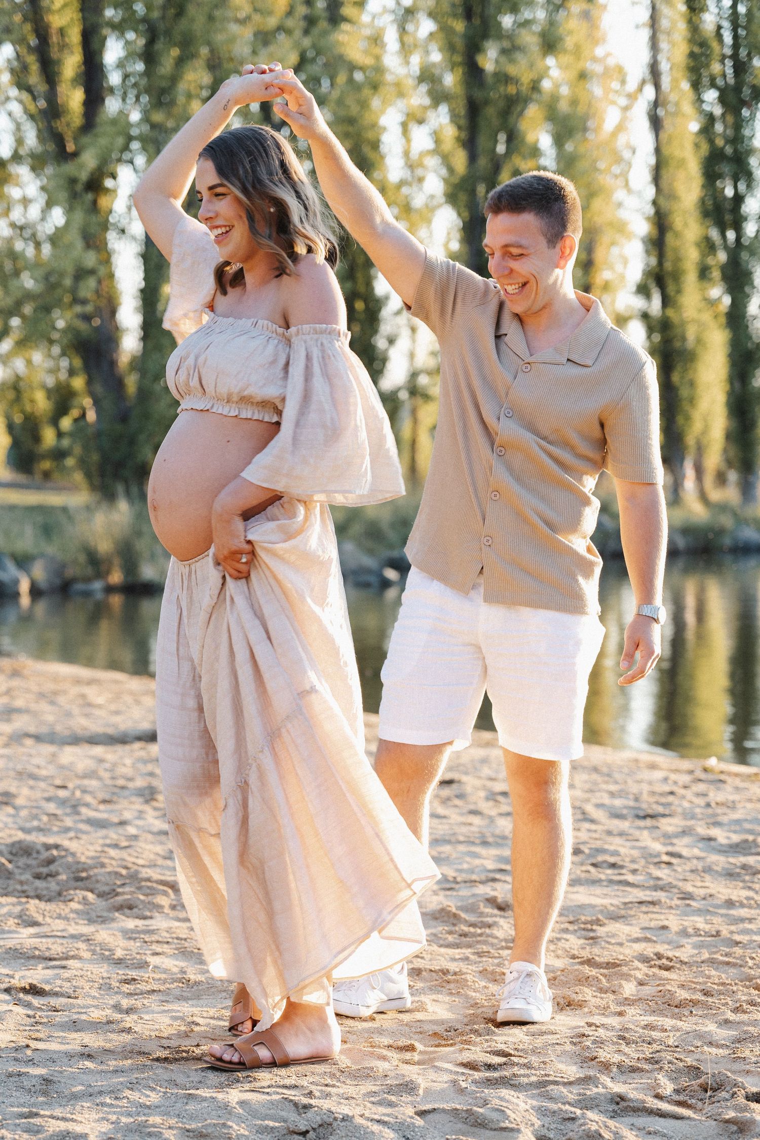 A dancing pregnant couple in Canberra in a candid outdoor maternity photoshoot