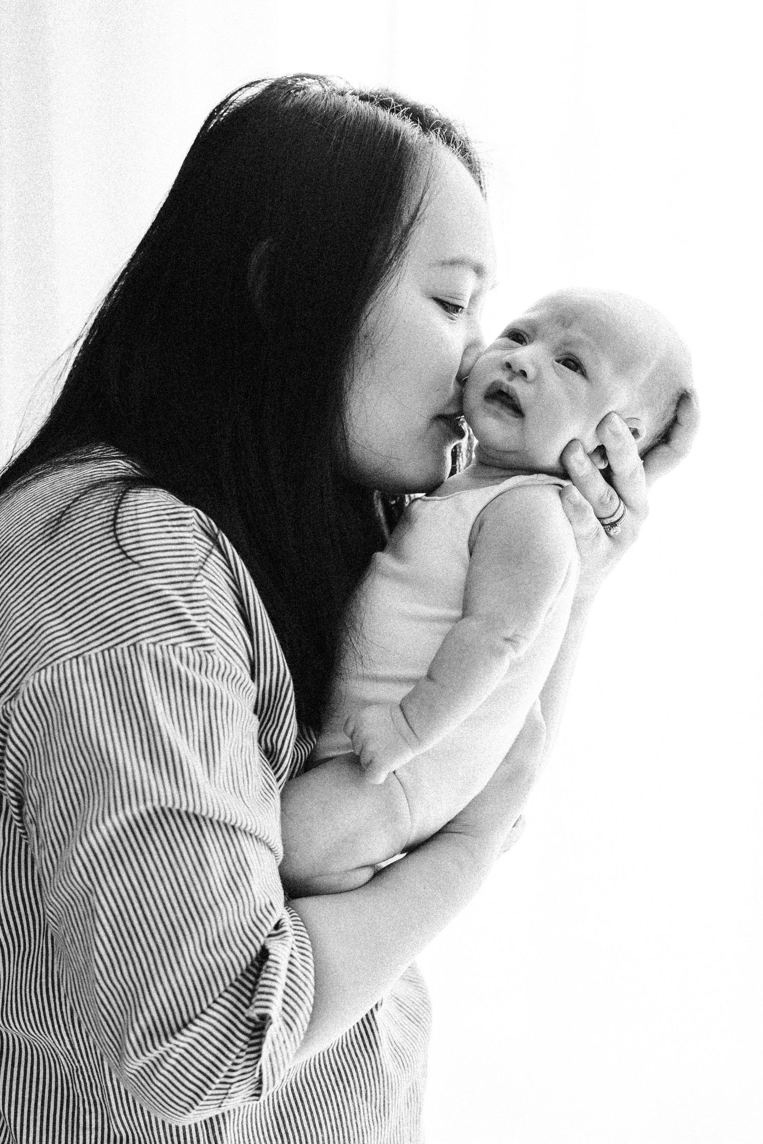 Newborn baby kissed by mum in Canberra