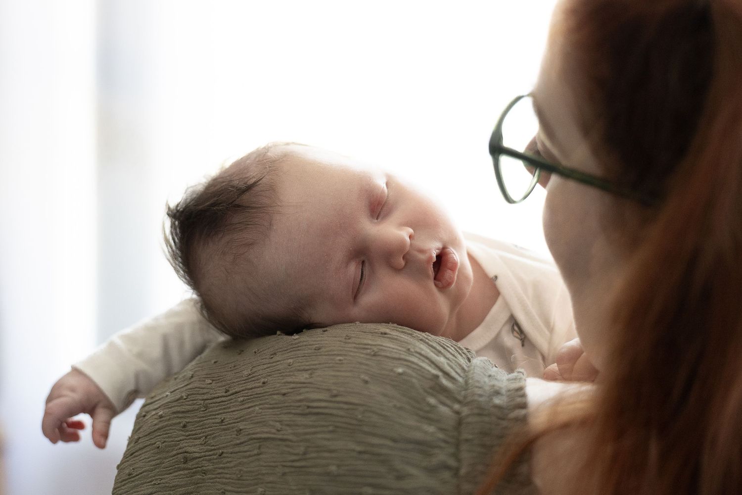 newborn baby sleeping on mum's shoulder in photography studio canberra