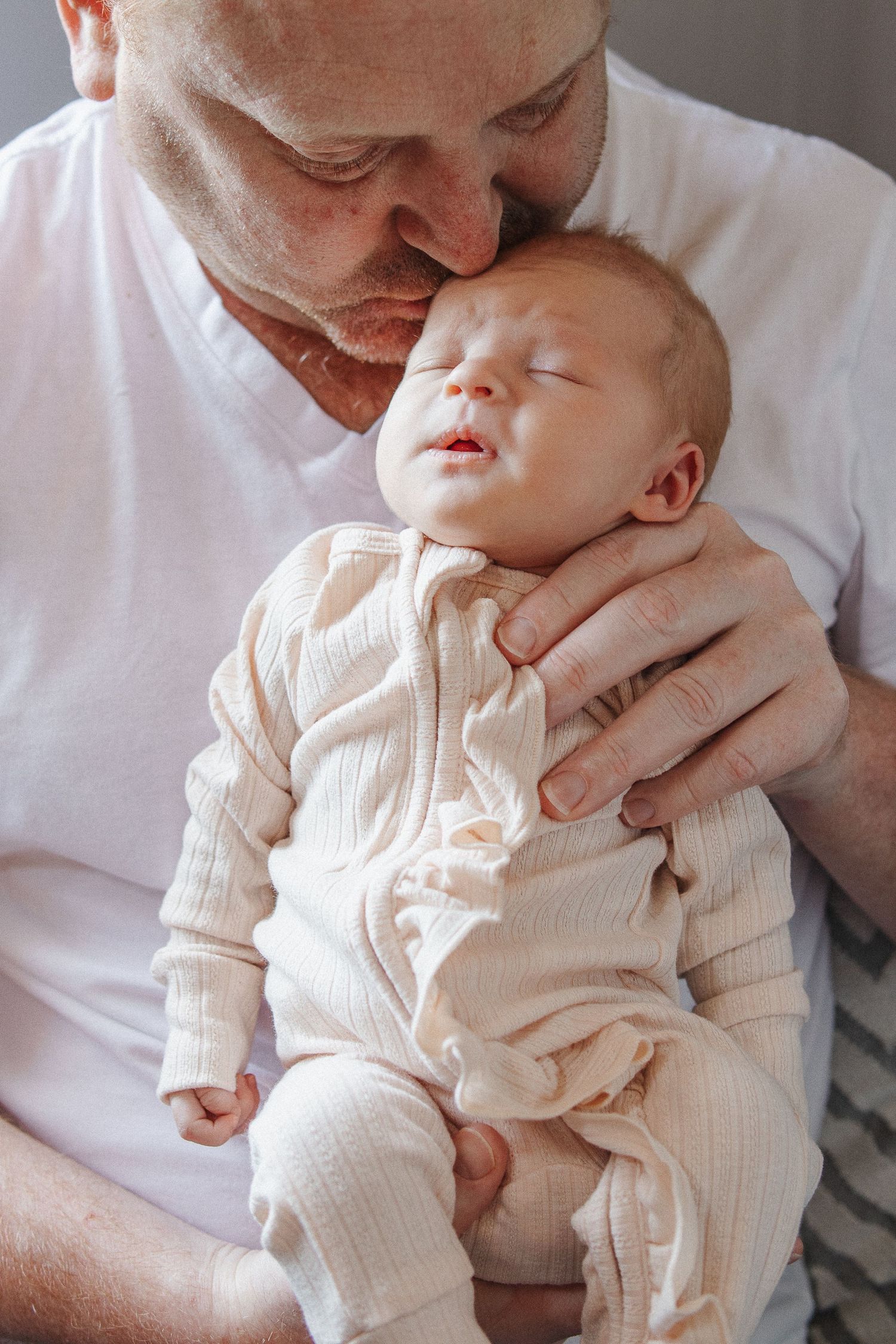 Father kisses newborn baby in Canberra