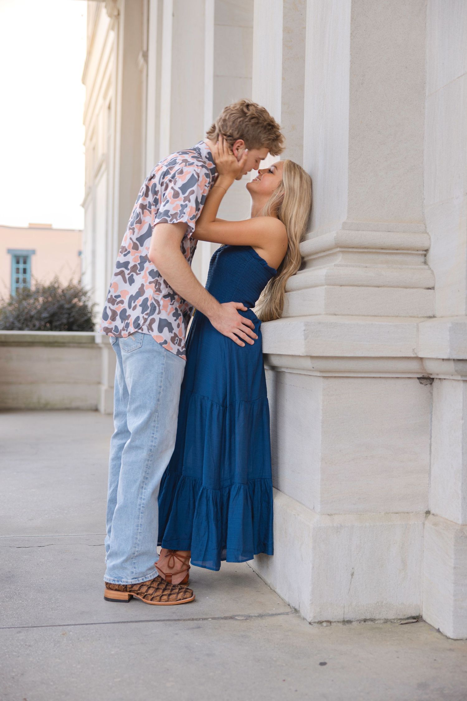 A romantic moment shared between a couple near white architectural columns.